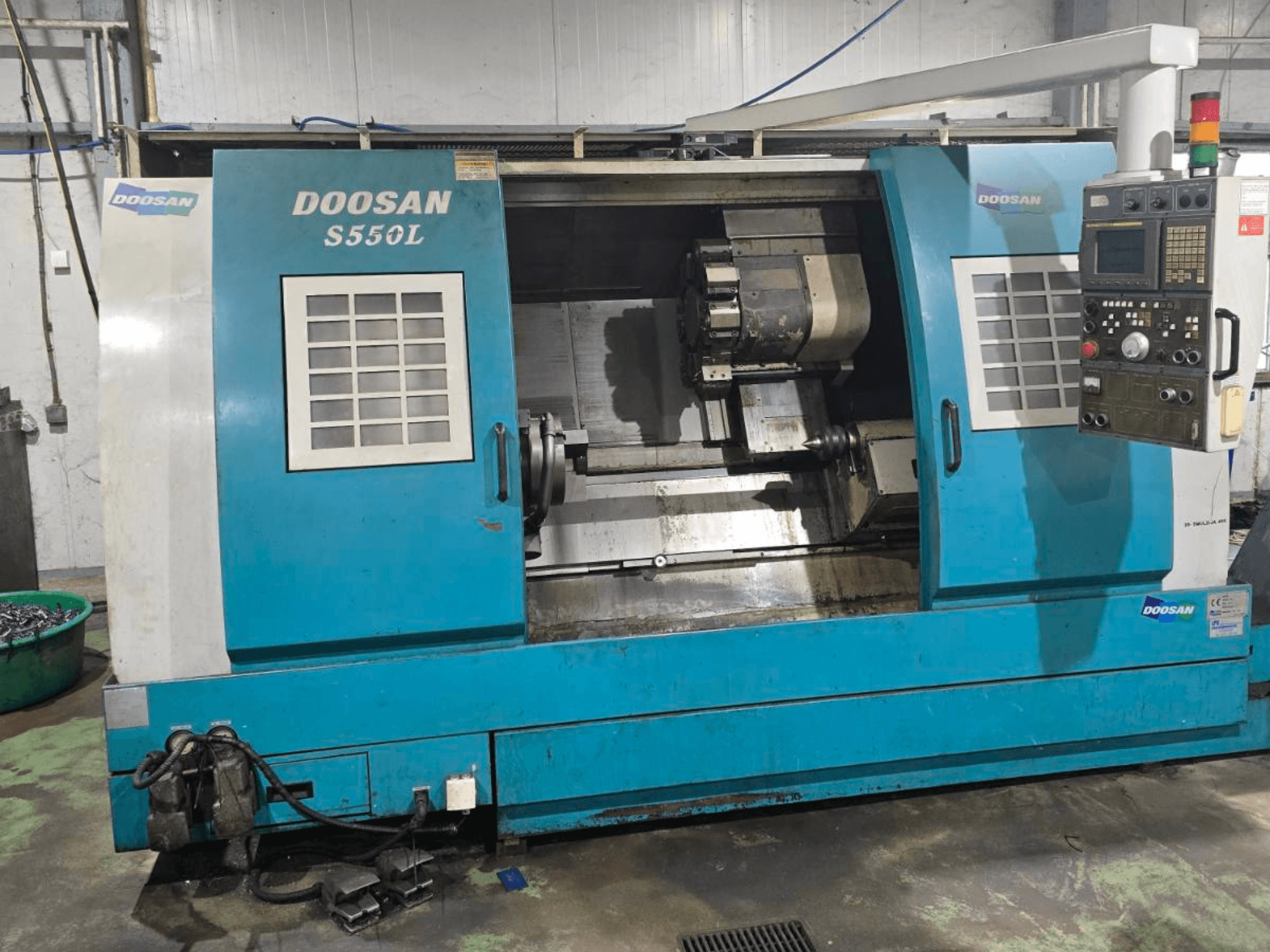 Tour horizontal DOOSAN S550L en vue latérale, doté d'un panneau de commande et d'un banc de tournage, idéal pour l'usinage de précision.