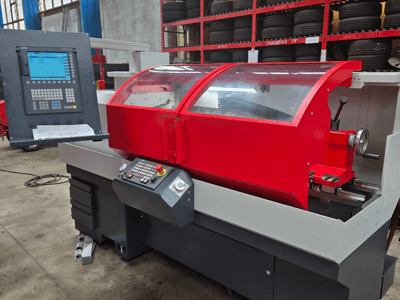 Tour CNC rouge avec panneau de commande, vue de face ; comprend un couvercle transparent, un porte-outil et des tiroirs de rangement.