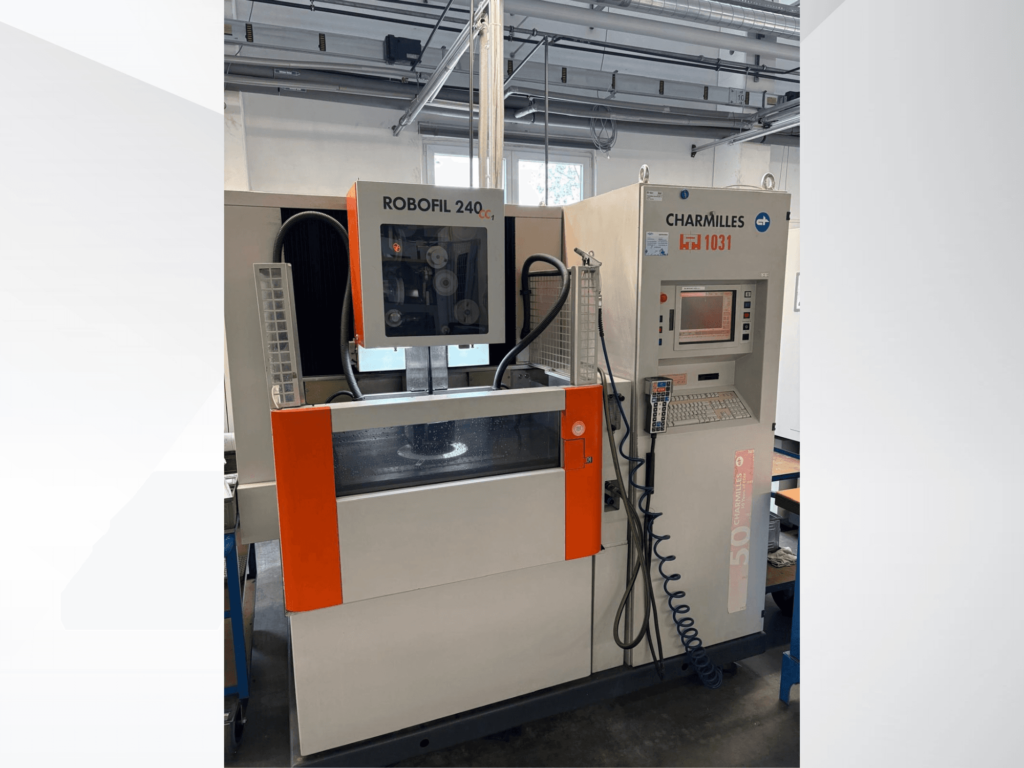 Machine d'électroérosion à fil CHARMILLES Robofil 240 CC, vue de face montrant le panneau de commande et le réservoir d'eau, avec des touches de couleur orange bien visibles.