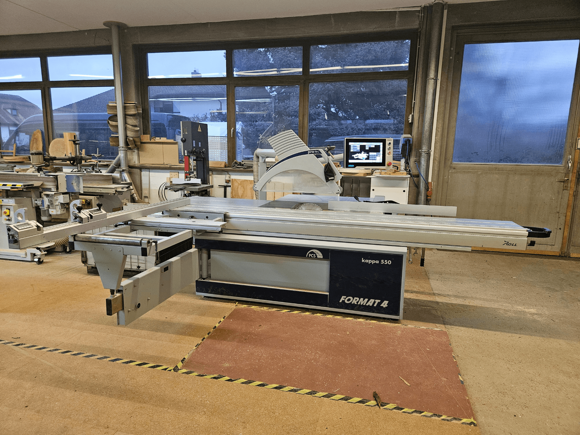 La machine de découpe du bois FORMAT4 kappa 550 vue de côté, avec sa table coulissante allongée et son moniteur intégré.