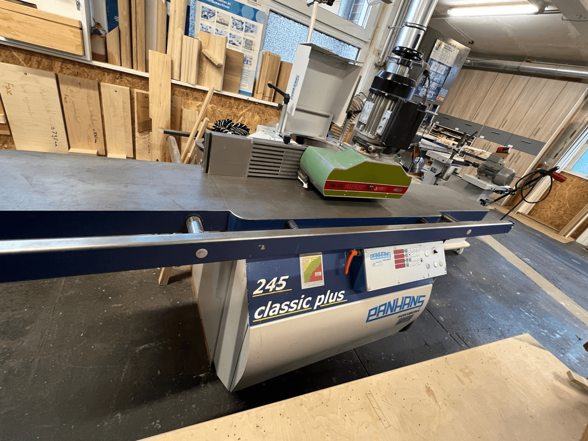 Toupie PANHANS 245 classic plus, vue de face montrant le moteur vert, le panneau de commande et le plan de travail dans un atelier.