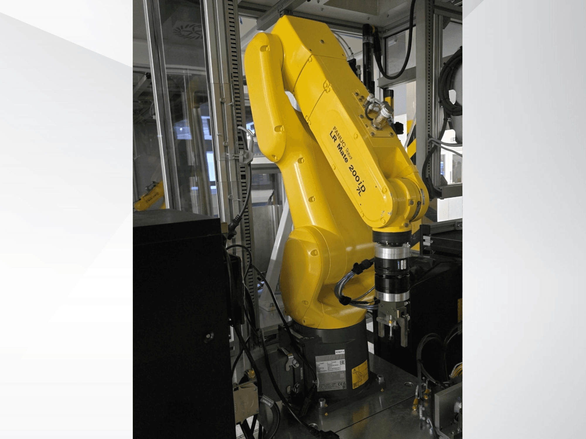 Bras robotique Fanuc LR Mate 200iD jaune, vu de côté, avec une pince et divers câbles attachés.
