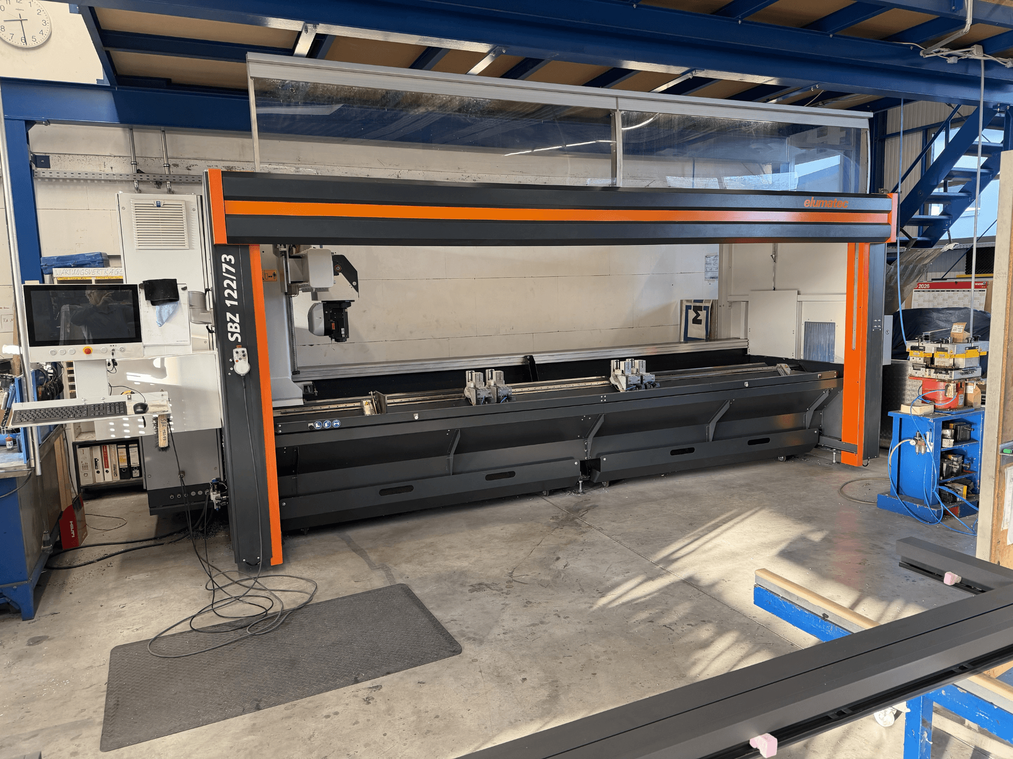 Machine-outil Elumatec SBZ 122/73 vue de face, montrant le panneau de commande, la zone de coupe et l'agencement de l'espace de travail.