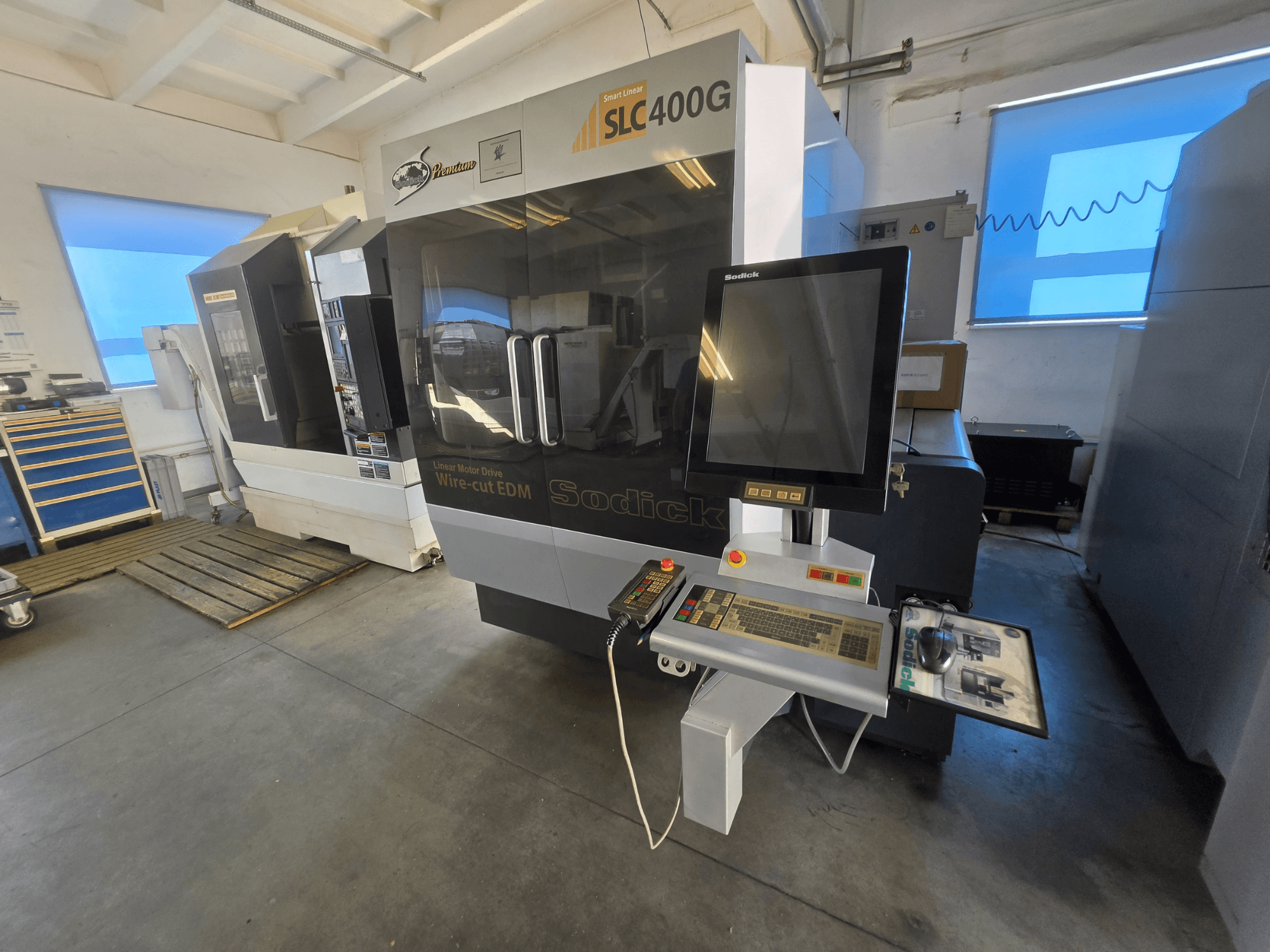 Machine d'électroérosion à fil Sodick SLC400G, vue de face avec le panneau de commande et l'écran tactile dans un atelier.