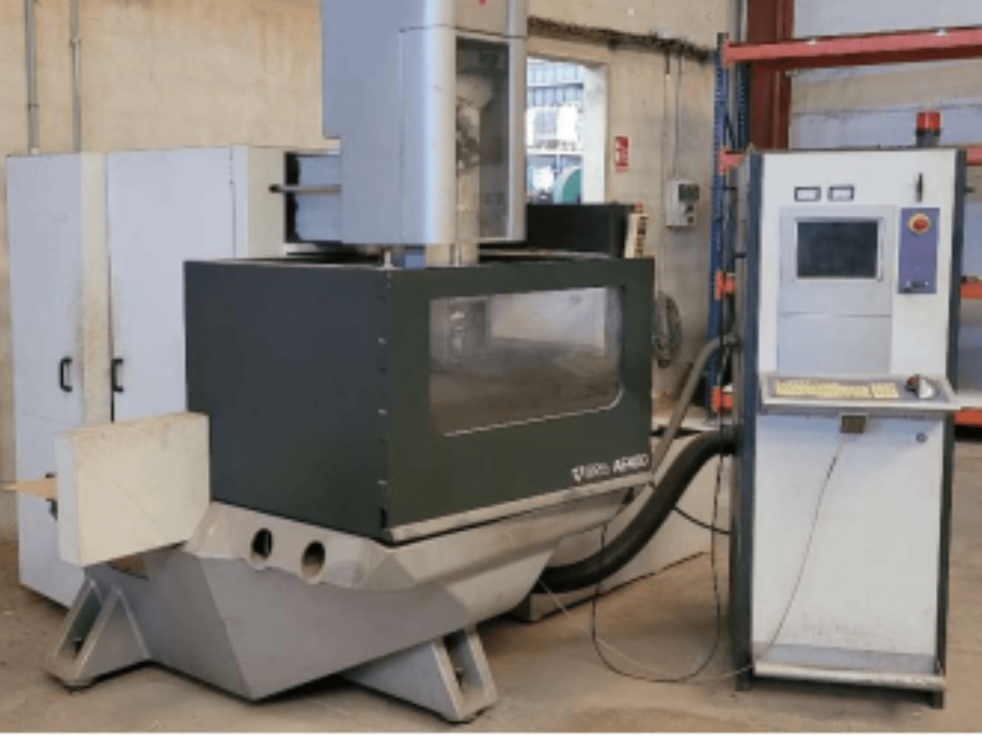 Machine d'électroérosion à fil ONA AE 400 dans un atelier, avec un panneau de commande à droite et une grande zone de coupe.