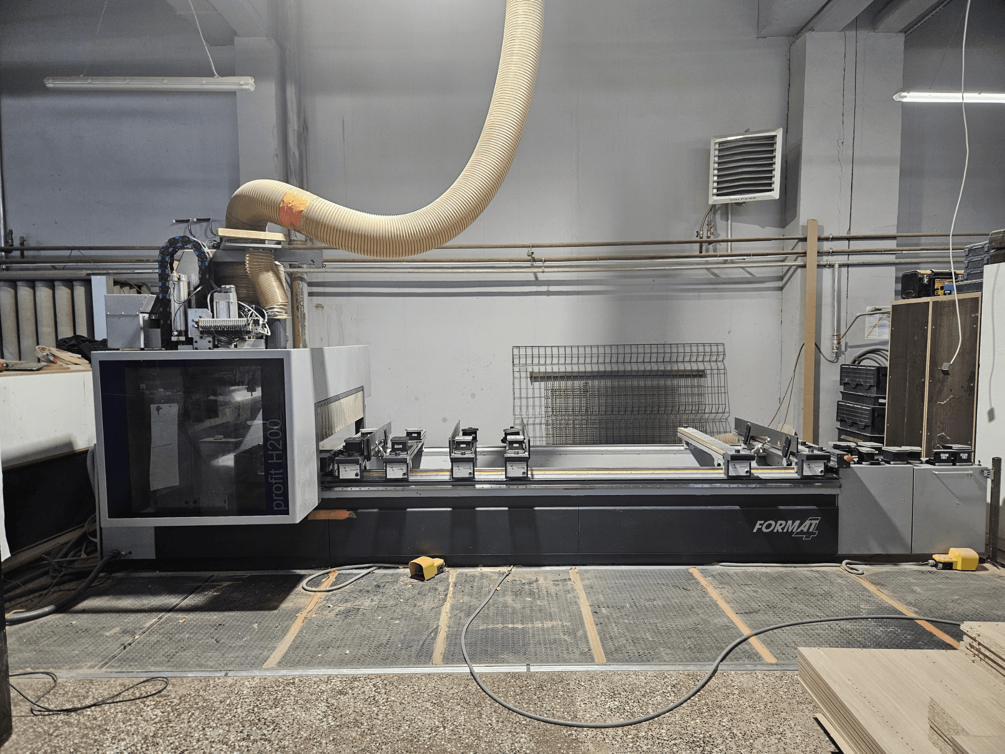 Une machine CNC FORMAT profit H200 dans un atelier, vue de côté, montrant la surface de travail et le système d'extraction des poussières.