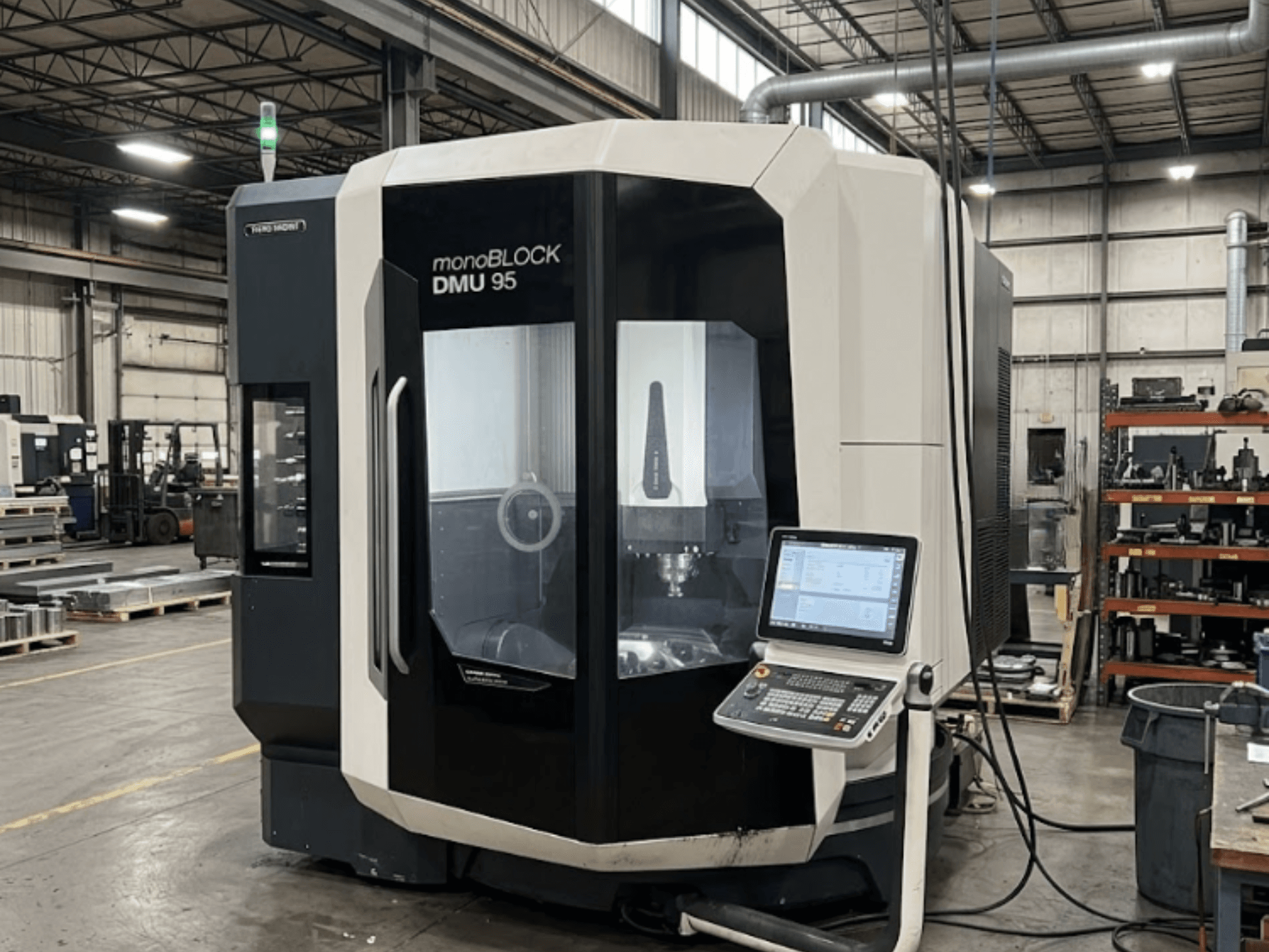 Centre d'usinage vertical DMG MORI DMU 95 Monoblock dans une usine, avec le panneau de commande visible, vue de face.