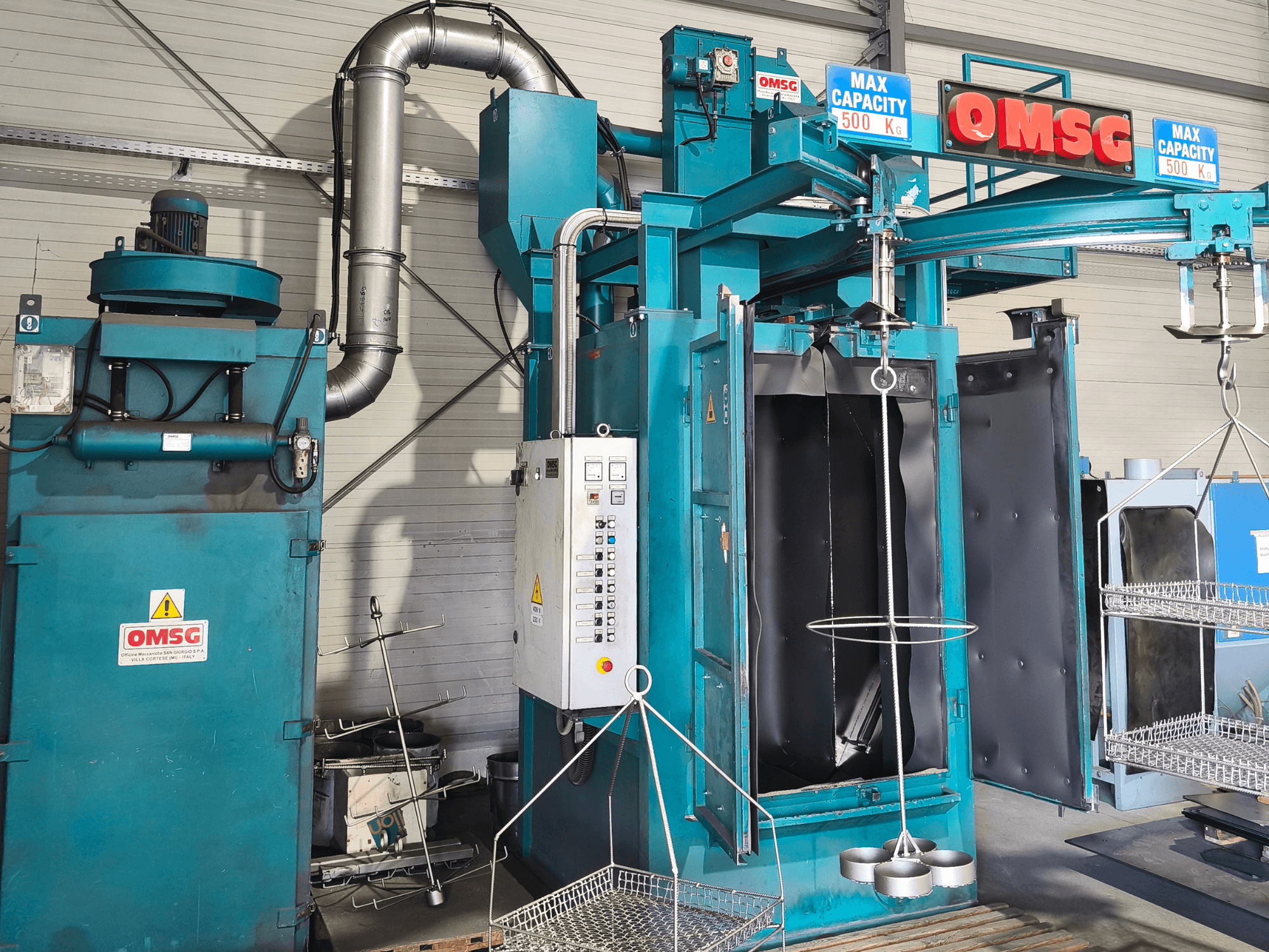 Machine de nettoyage industriel OMSG d'une capacité maximale de 500 kg, présentant le panneau de commande et la chambre ouverte pour le nettoyage des pièces.