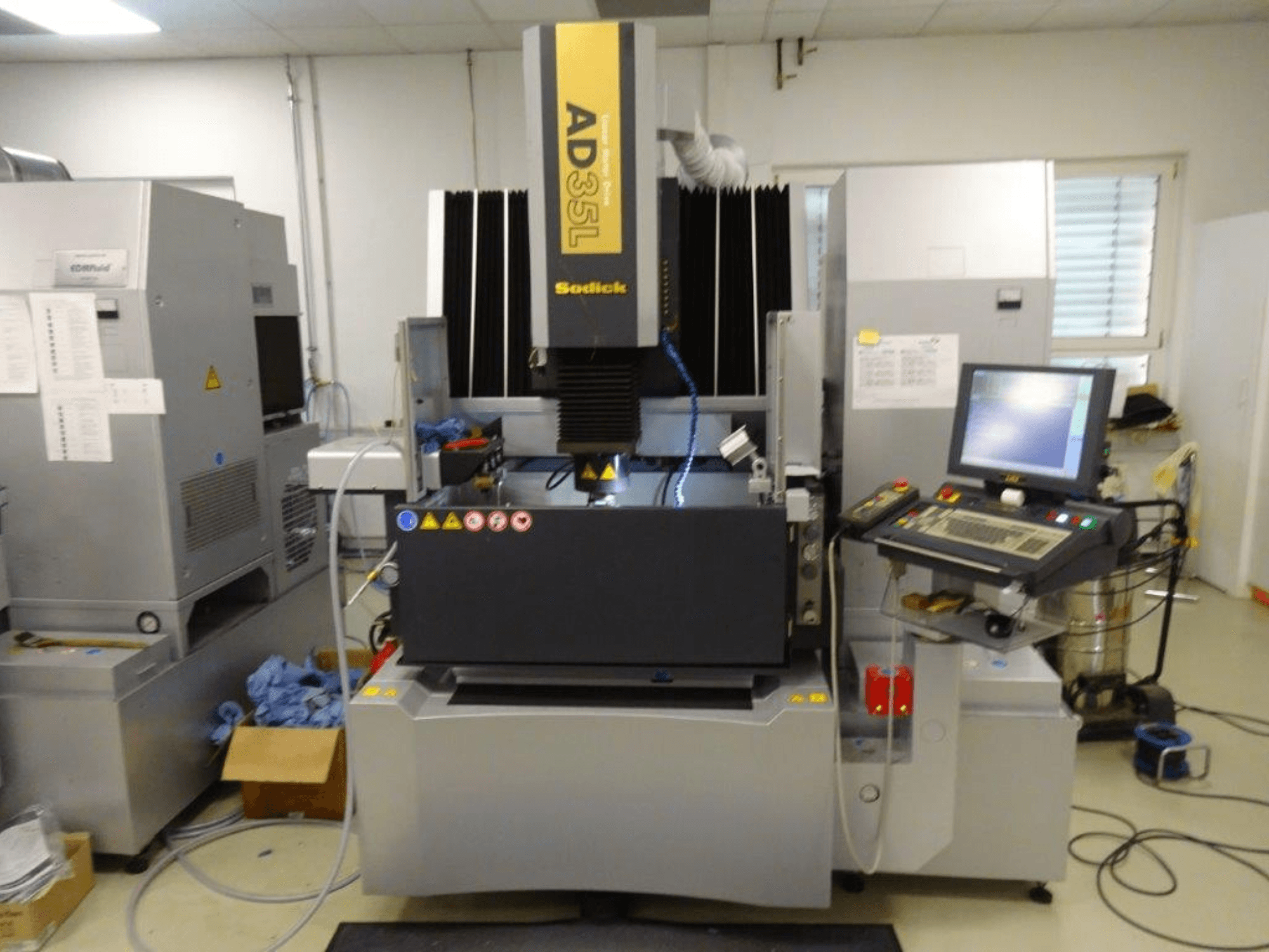 Machine à décharge électrique Sodick AD35L, vue de face avec le panneau de commande, le système de refroidissement et la zone de travail visibles.