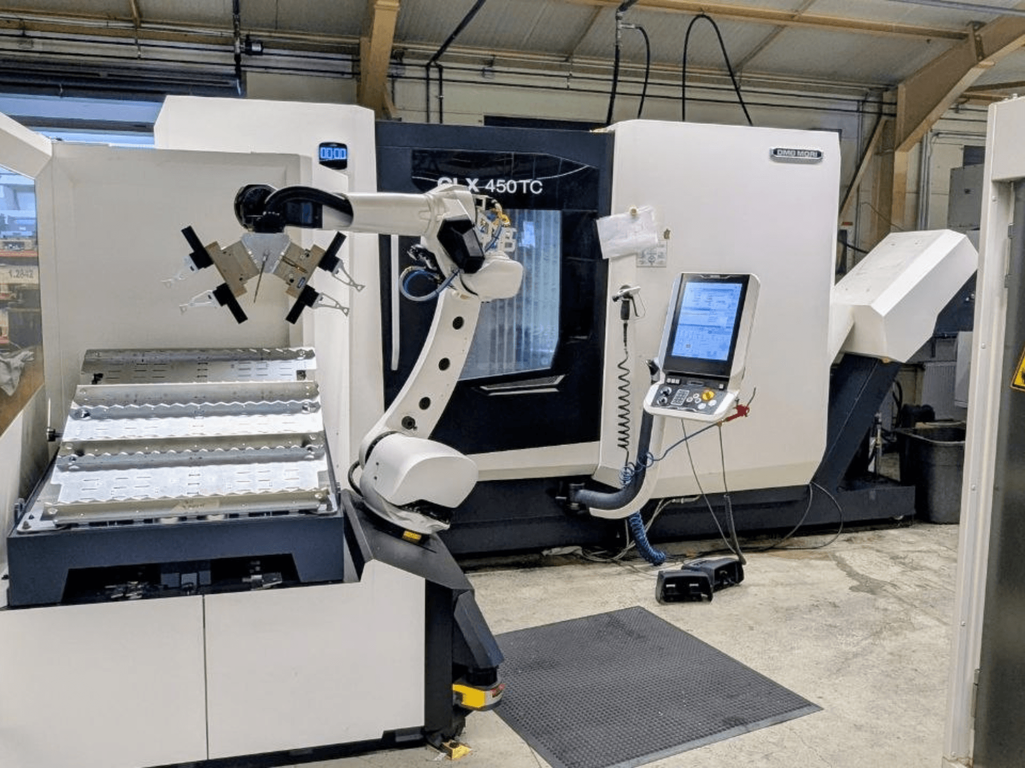 DMG MORI CLX 450 TC équipée du système Robo2go, vue de face, mettant en évidence le bras robotisé et le panneau de commande situés à côté de la machine.