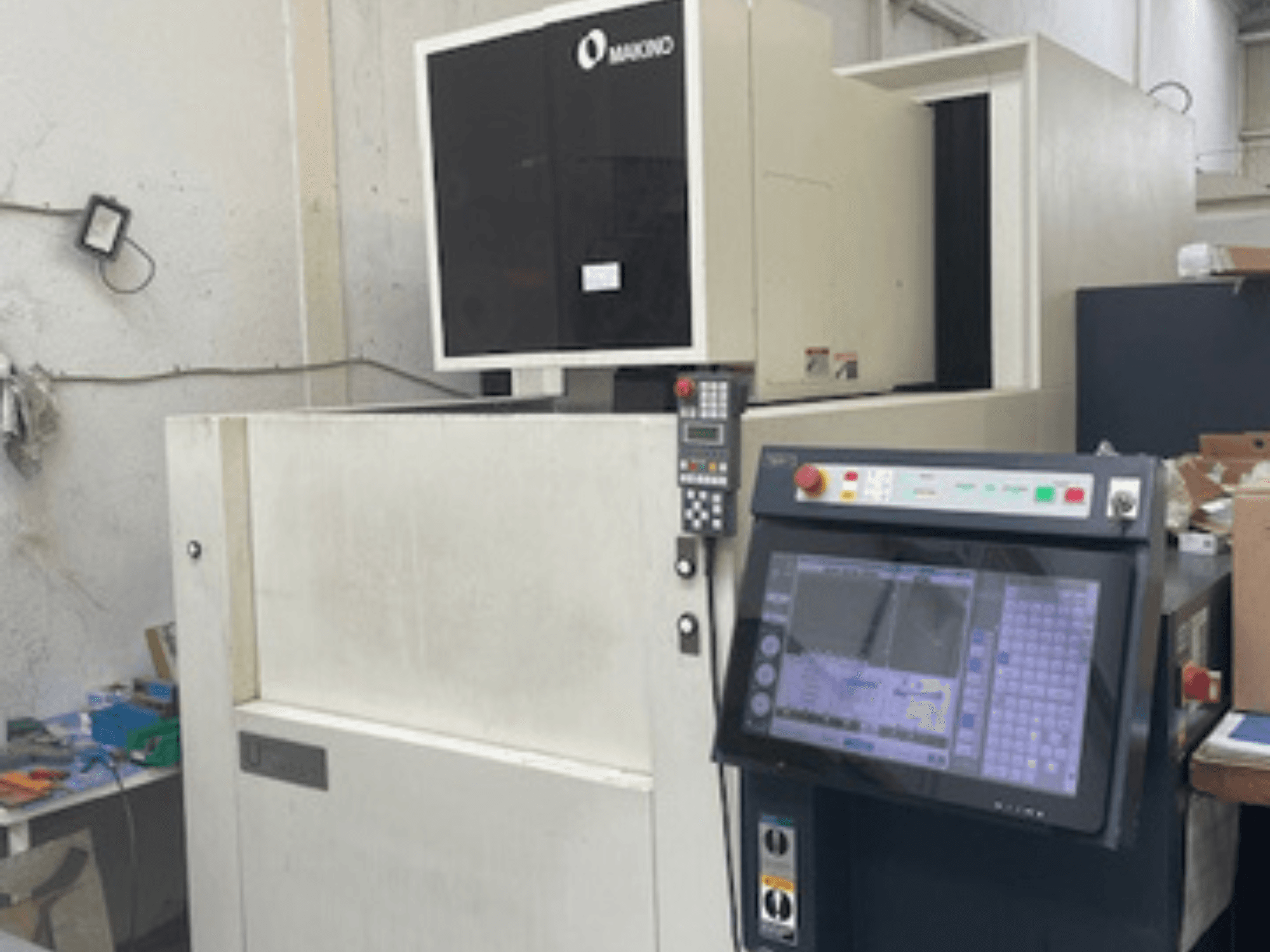 Machine d'électroérosion à fil Makino U6 HEAT dans un atelier, vue de face montrant le panneau de commande et l'affichage numérique.