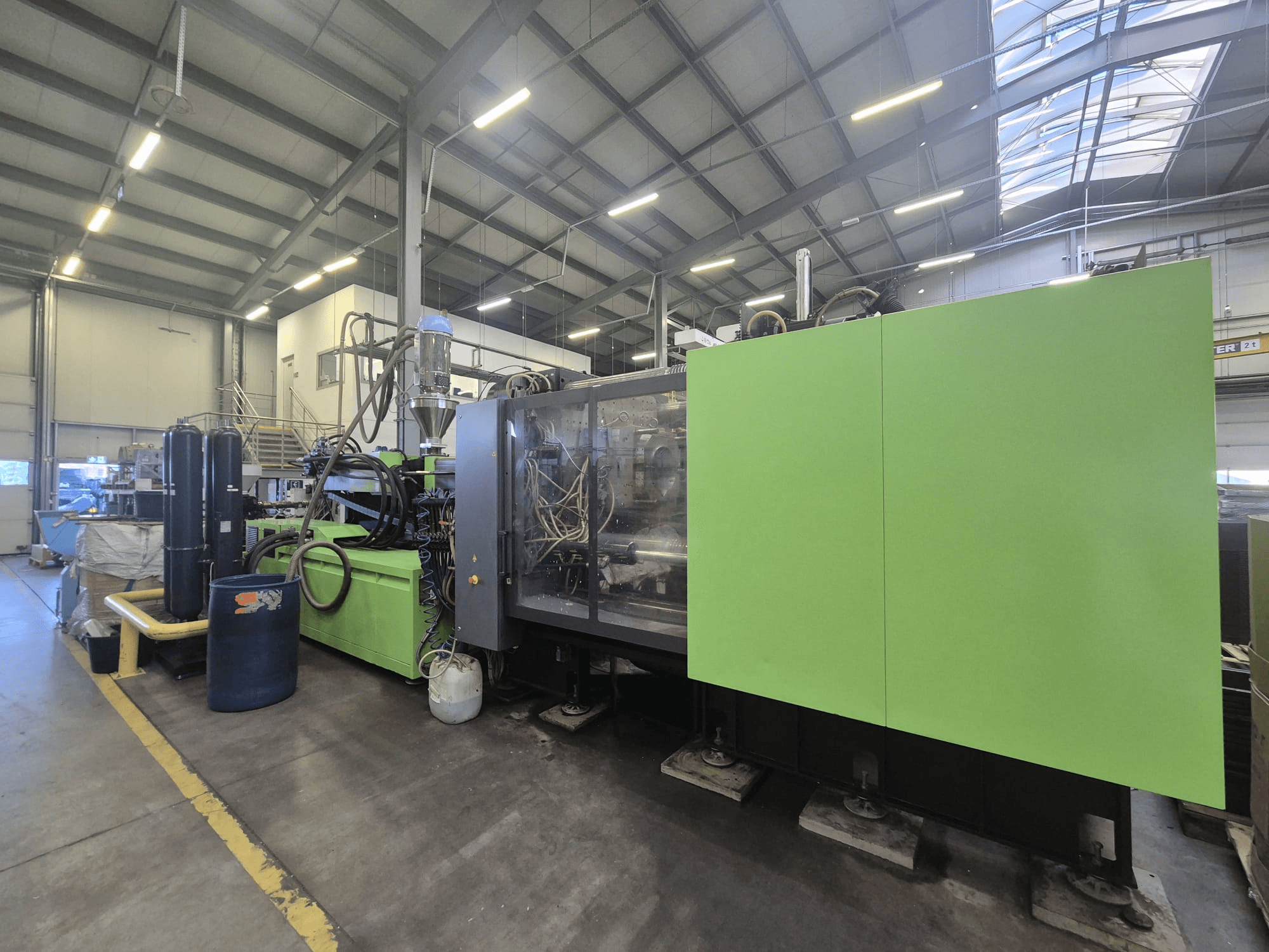 Machine de moulage par injection hydraulique Engel duo 5160/700 dans un environnement d'usine, vue de profil, mettant en valeur sa carrosserie verte et ses composants.