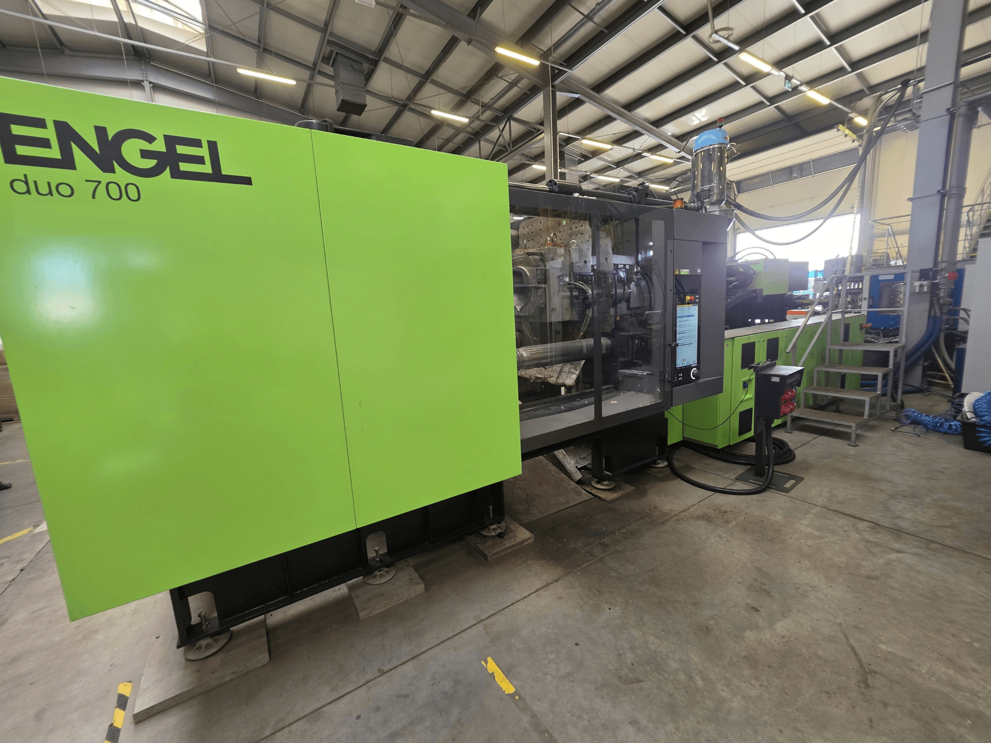 Presse à injection hydraulique Engel Duo 700, vue de face, montrant la carrosserie verte et le panneau de commande.