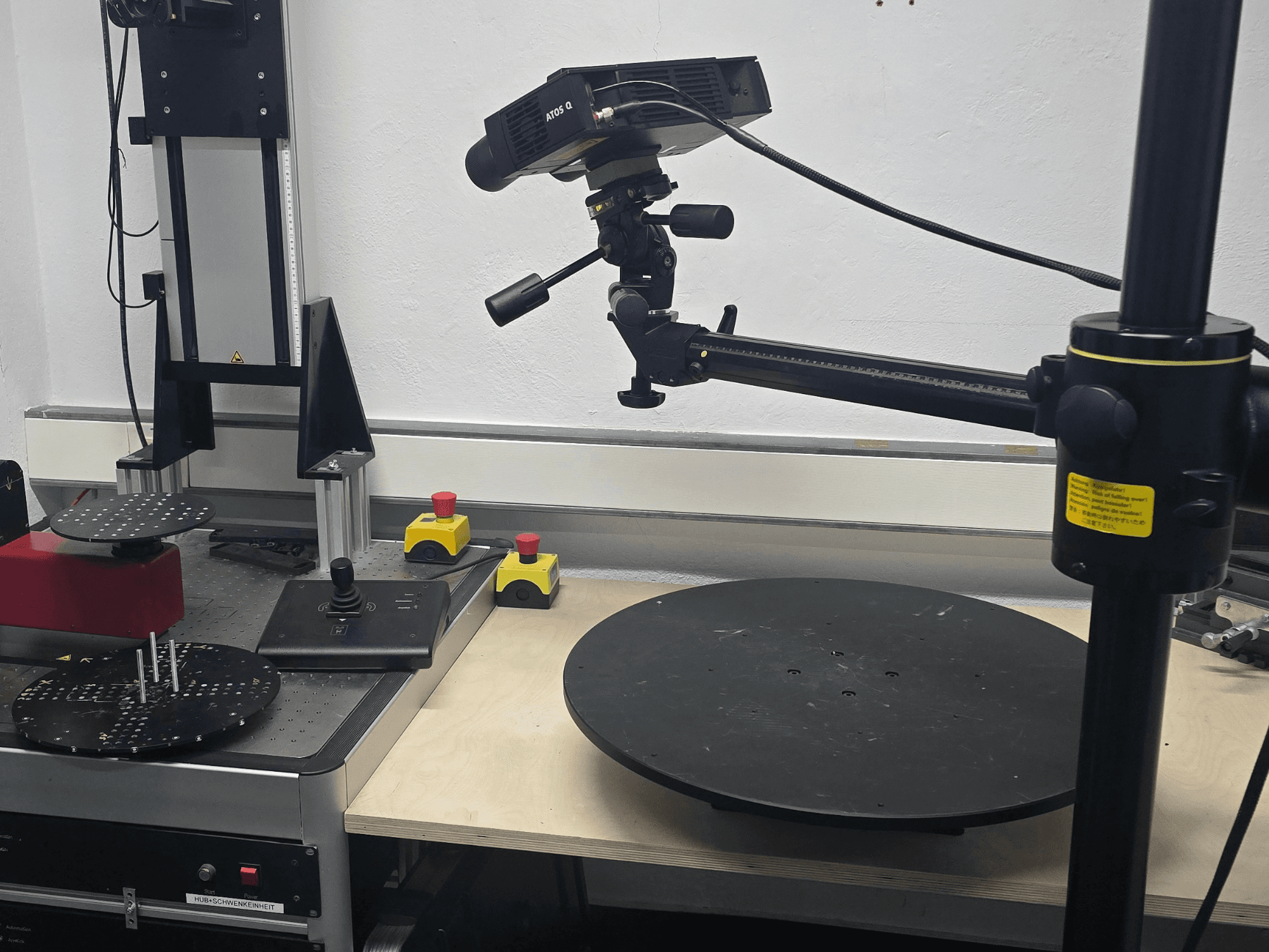 Vue de face de la machine de mesure optique ZEISS ATOS Q 12M, équipée d'une tête de balayage, d'un panneau de commande et d'une plate-forme circulaire rotative.