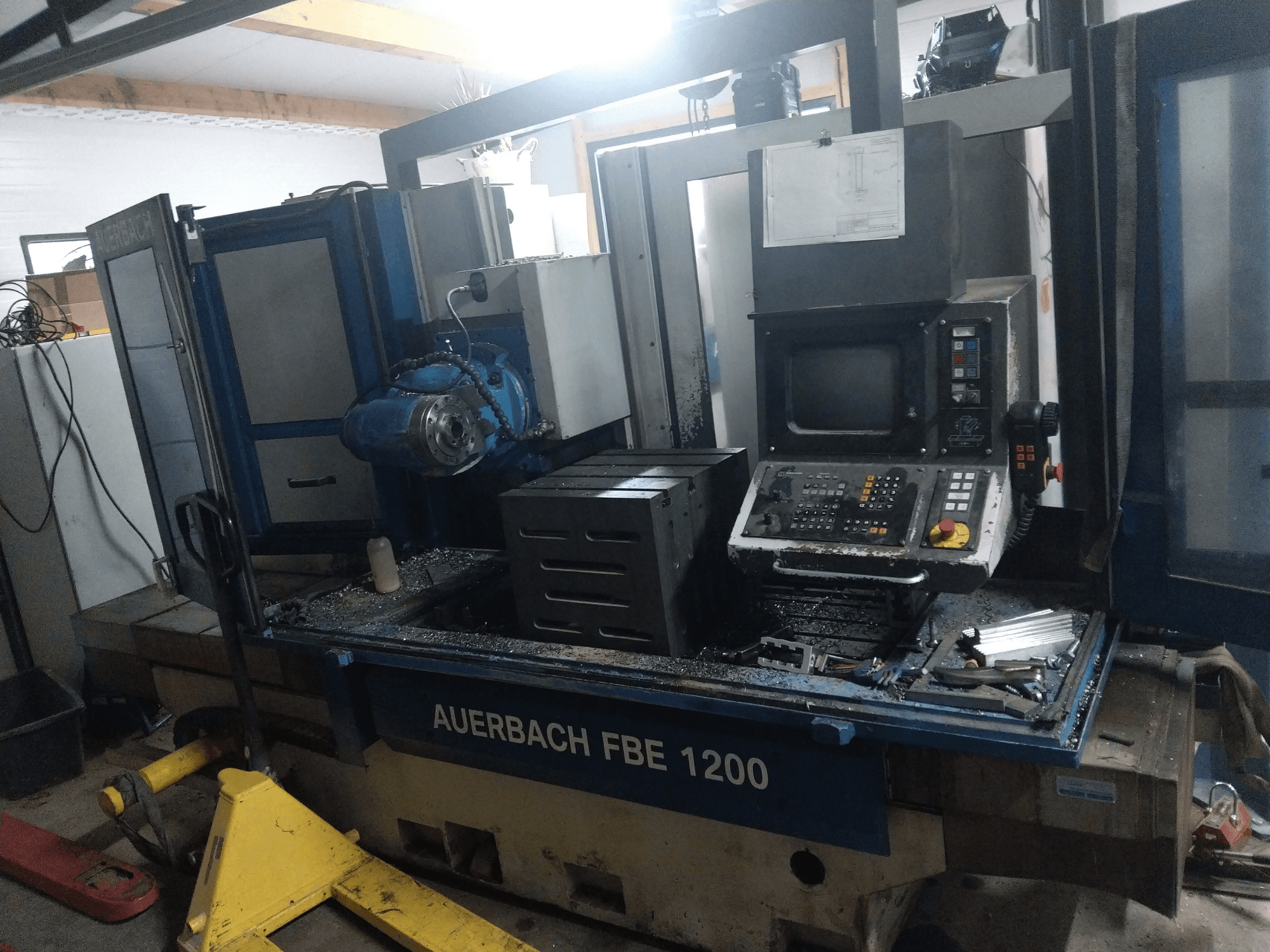 Perceuse de métaux Auerbach FBE 1200, vue de face, montrant le panneau de commande, le moteur et les copeaux de métal sur la surface de travail.