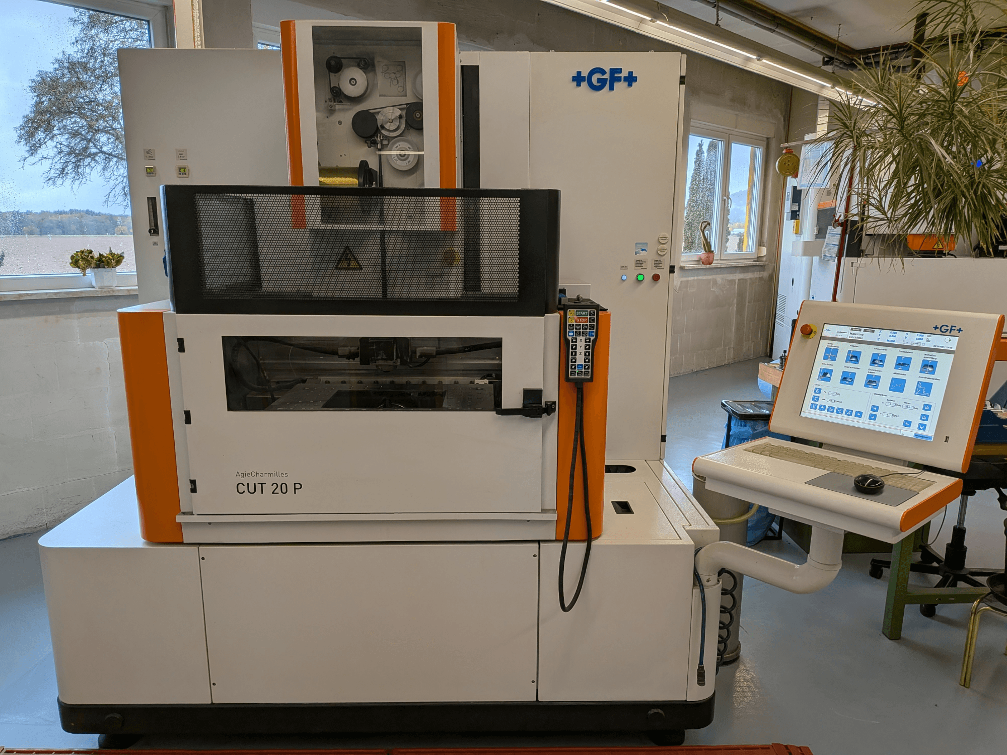 Machine d'électroérosion à fil AgieCharmilles Cut-20 P, vue de face avec le panneau de commande et l'écran, installée dans un atelier bien éclairé.