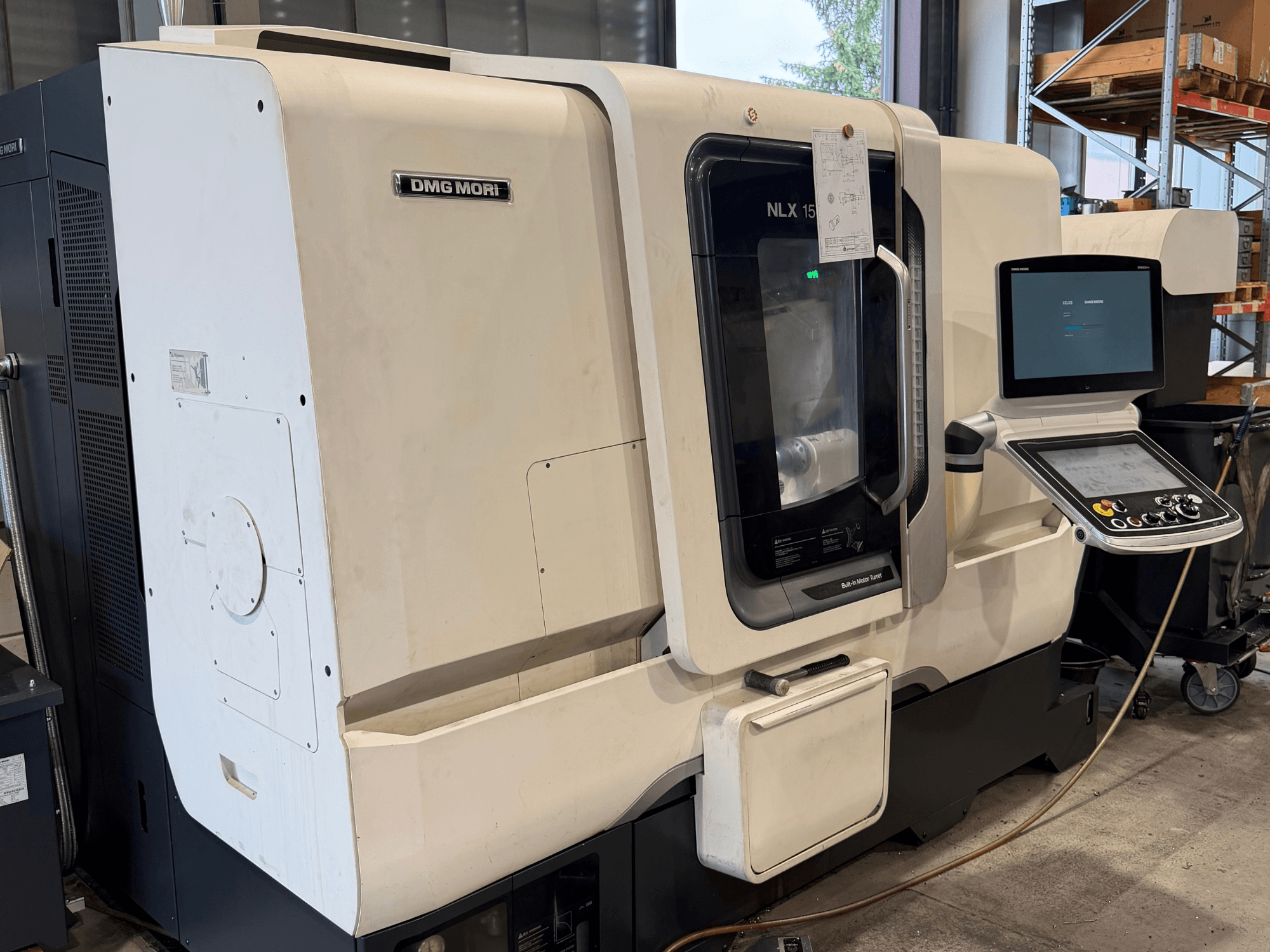 Vue de face du tour horizontal DMG MORI NLX1500MC/500, montrant le panneau de commande et la zone de la broche à travers un capot transparent.