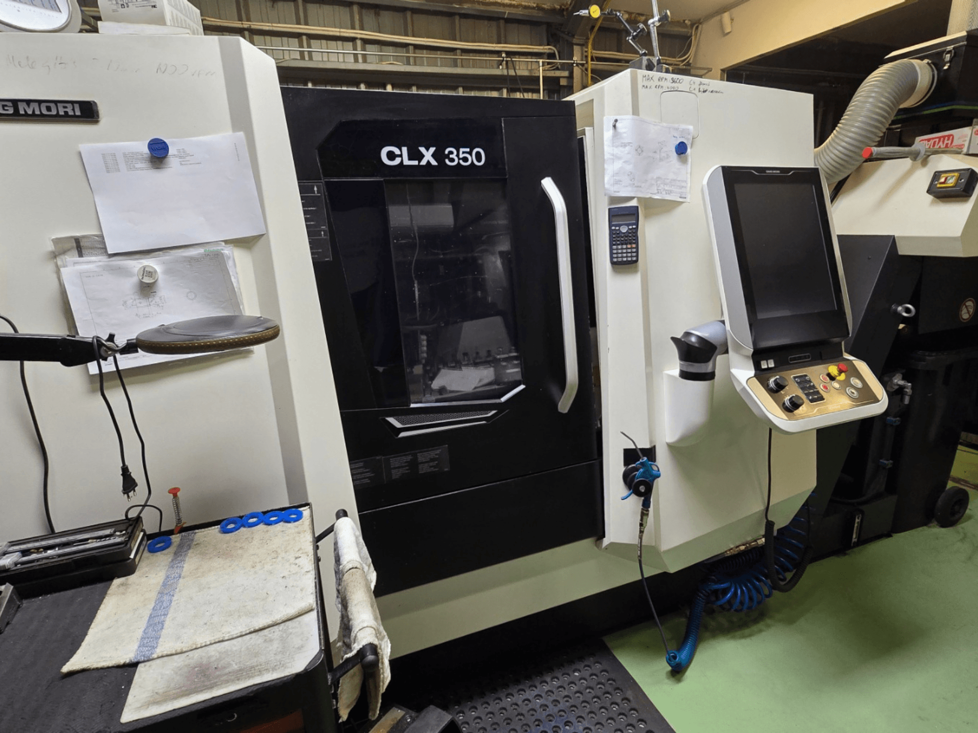 Tour CNC DMG MORI CLX 350 dans un atelier ; vue de face avec panneau de commande, outils et espace de travail visibles.