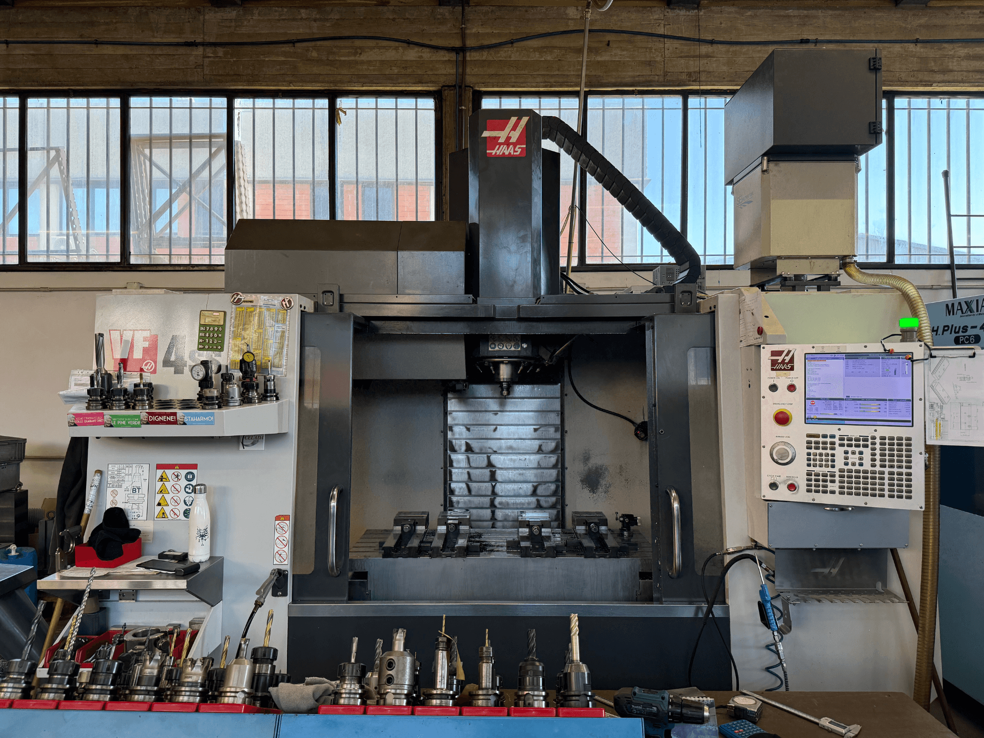 Centre d'usinage vertical HAAS VF-4SS, vue de face, montrant le panneau de commande, les porte-outils et la zone de la broche.