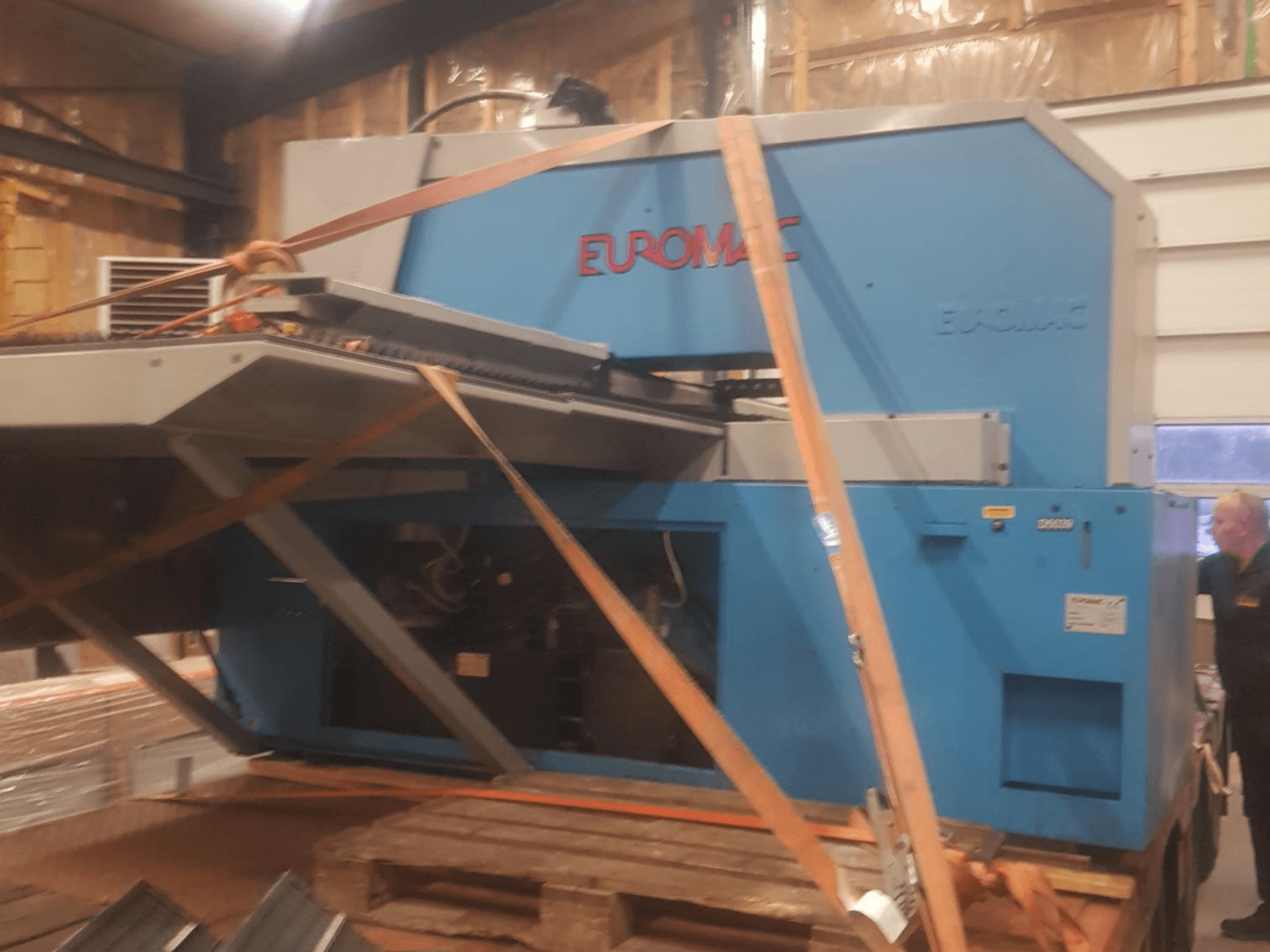 Machine de poinçonnage CNC Euromac ZX INDEX vue de côté, sécurisée par des sangles, présentant une finition métallique bleue.
