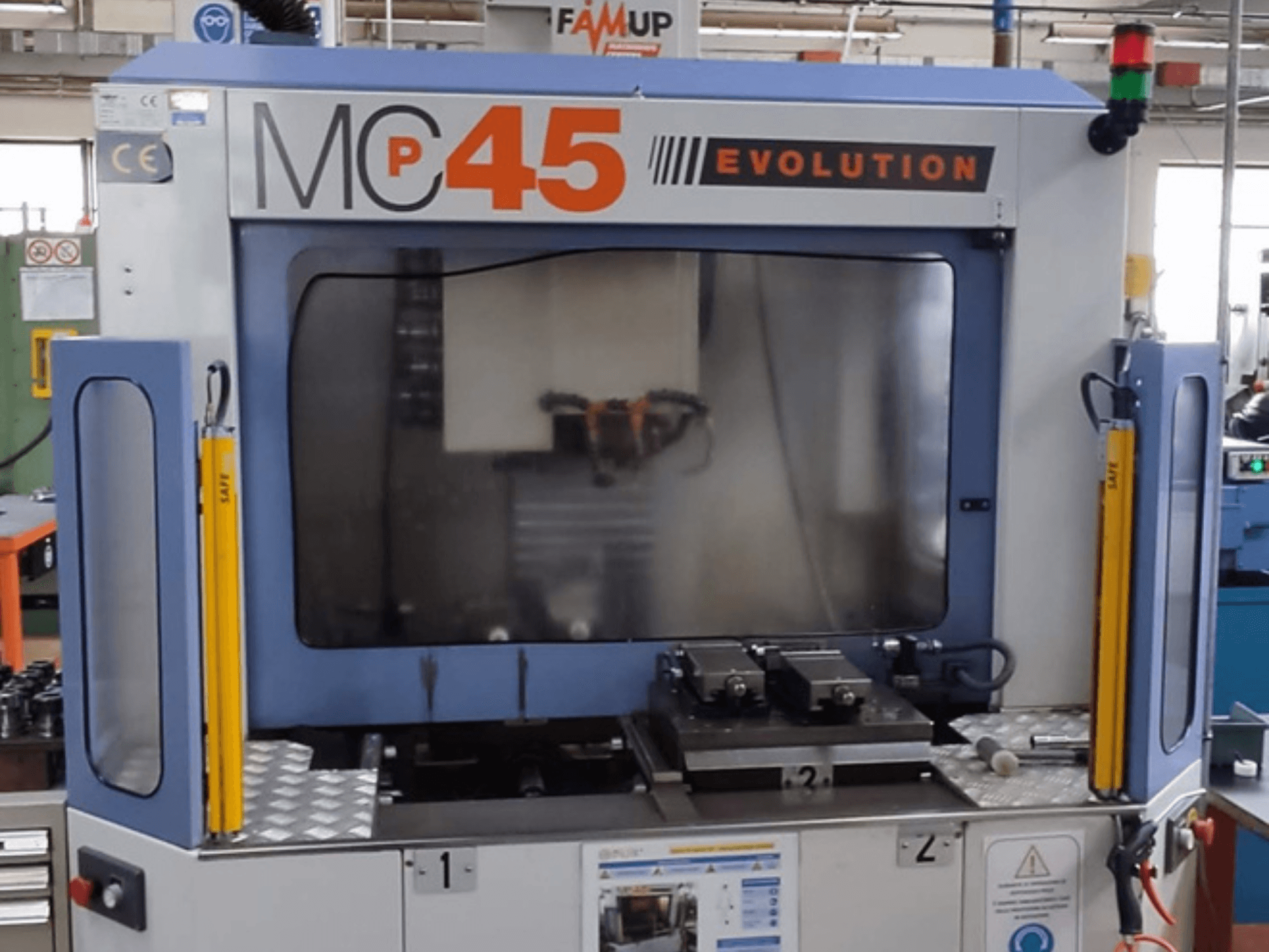 Centre d'usinage vertical FAMUP MCP 45 E en vue frontale, montrant les commandes opérationnelles et la zone de travail de fraisage.