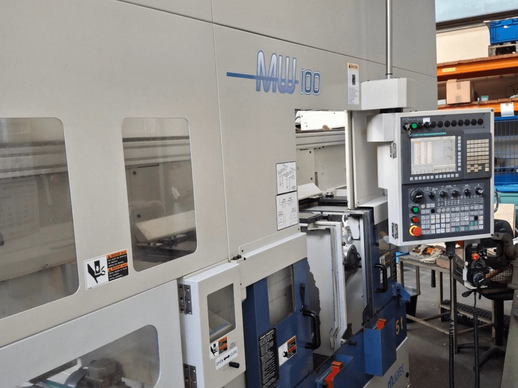 Tour multibroche Muratec MW 100 GT, vue de face, présentant le panneau de commande et les compartiments de la machine.