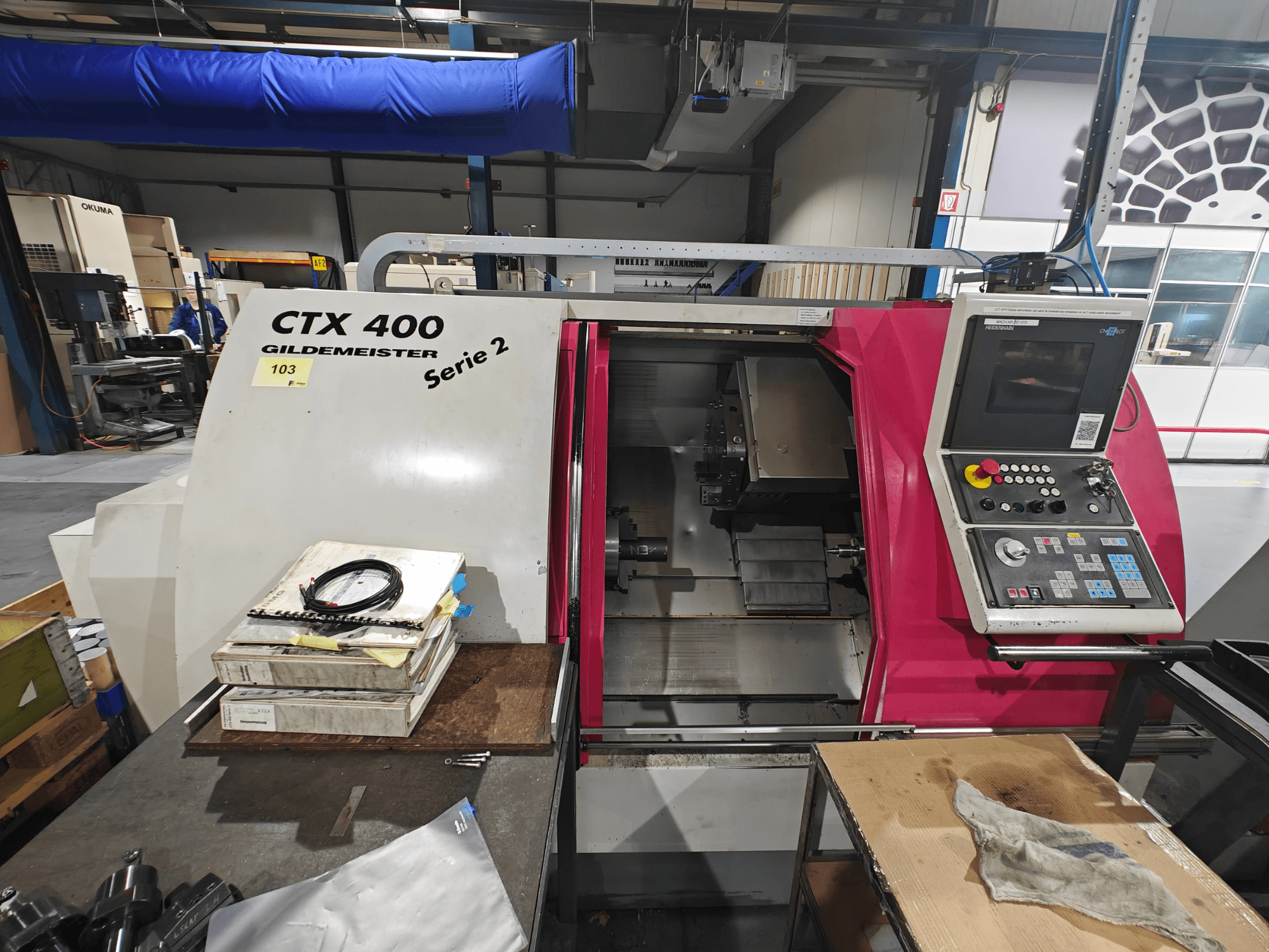 Tour CTX 400 Gildemeister présenté de face, avec un panneau de commande à boutons, un écran et un espace de travail.