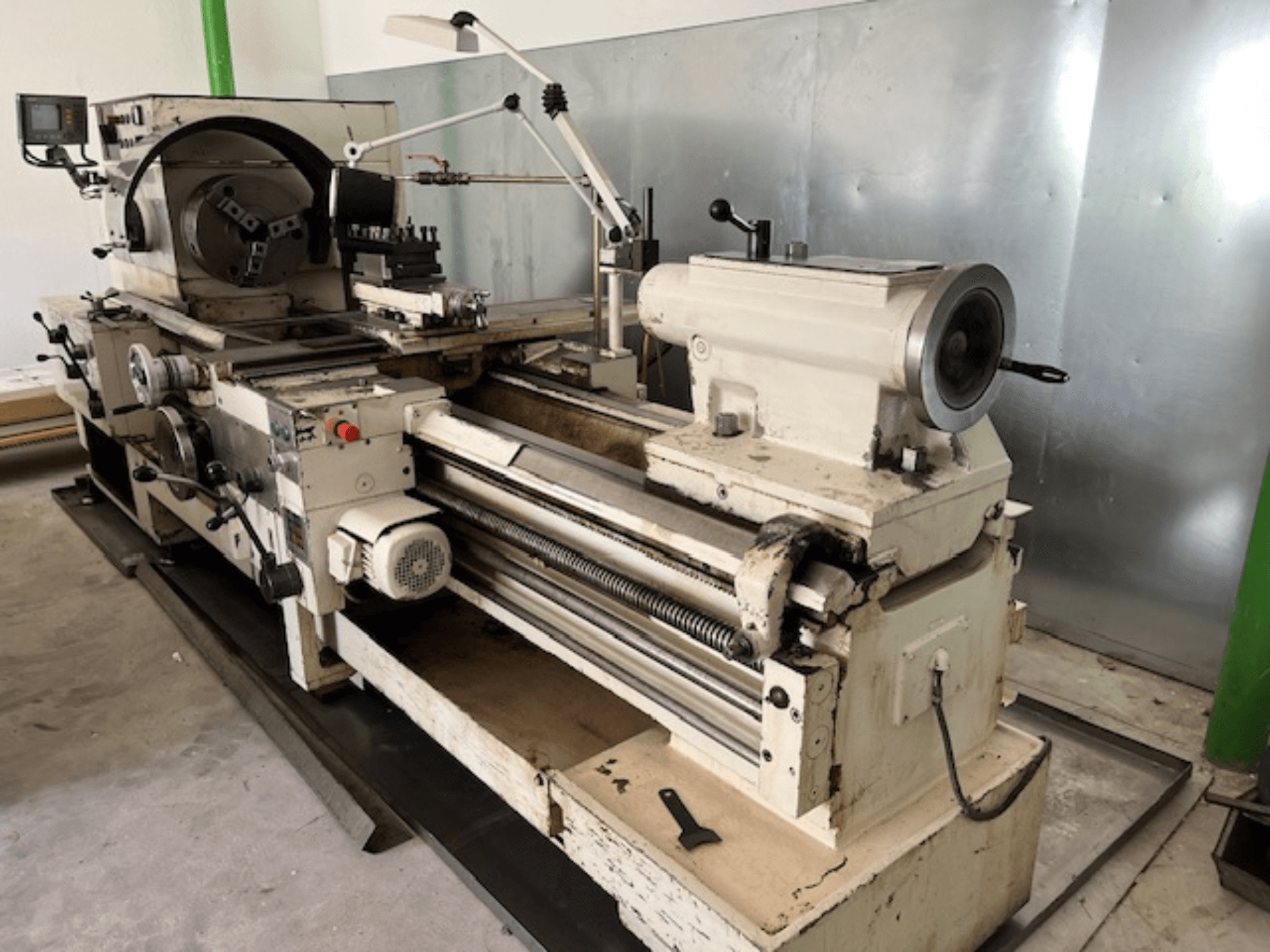 Tour à métaux d'époque avec panneau de commande et outils, vue latérale, montrant les éléments opérationnels et la finition du métal.