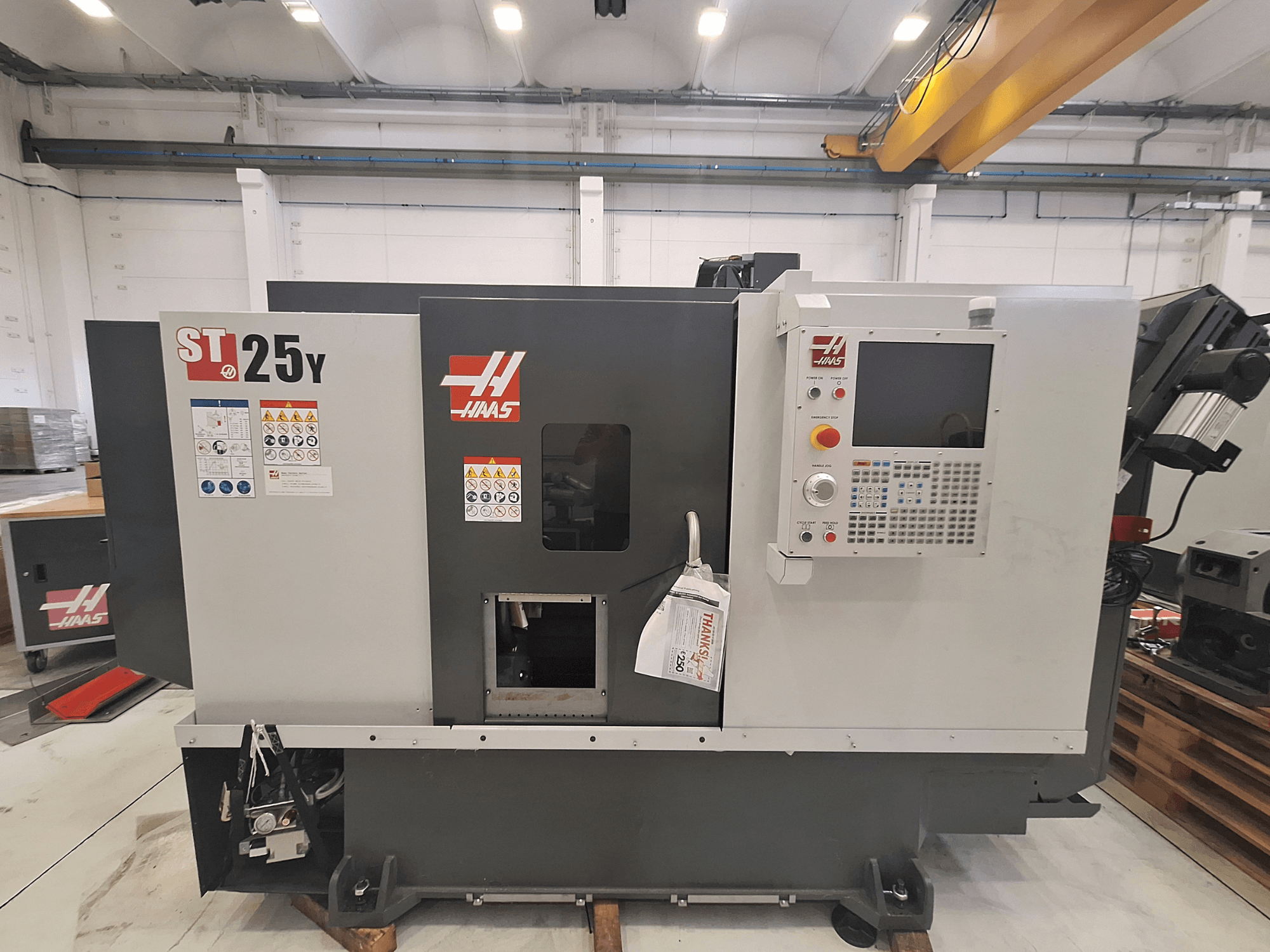 Tour horizontal Haas ST-25Y, vue de face, avec panneau de commande et étiquettes de sécurité. Idéal pour l'usinage de précision.