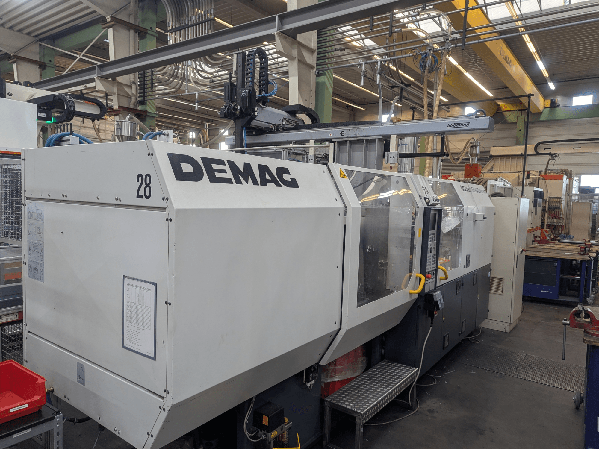 Vue avant d'une machine de moulage par injection hydraulique DEMAG ERGOTECH 1500-840, présentant les commandes opérationnelles et les dispositifs de sécurité.