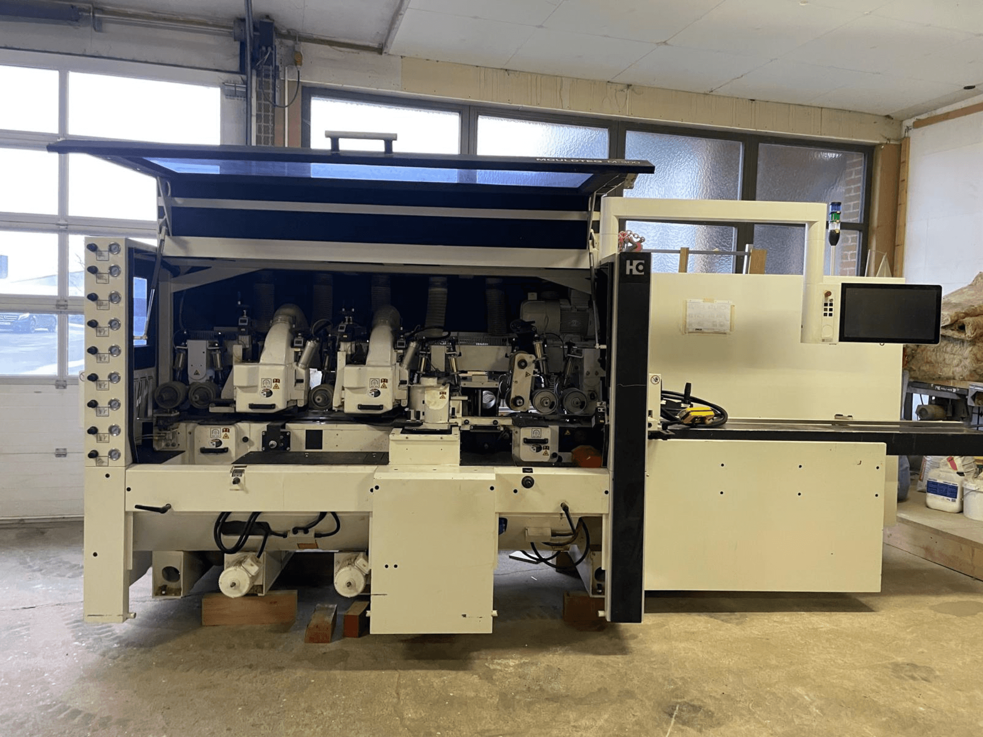 Machine CNC Häwa, vue de face, équipée de plusieurs broches, d'un panneau de commande et de tuyaux d'extraction de la poussière, adaptée au traitement du bois.