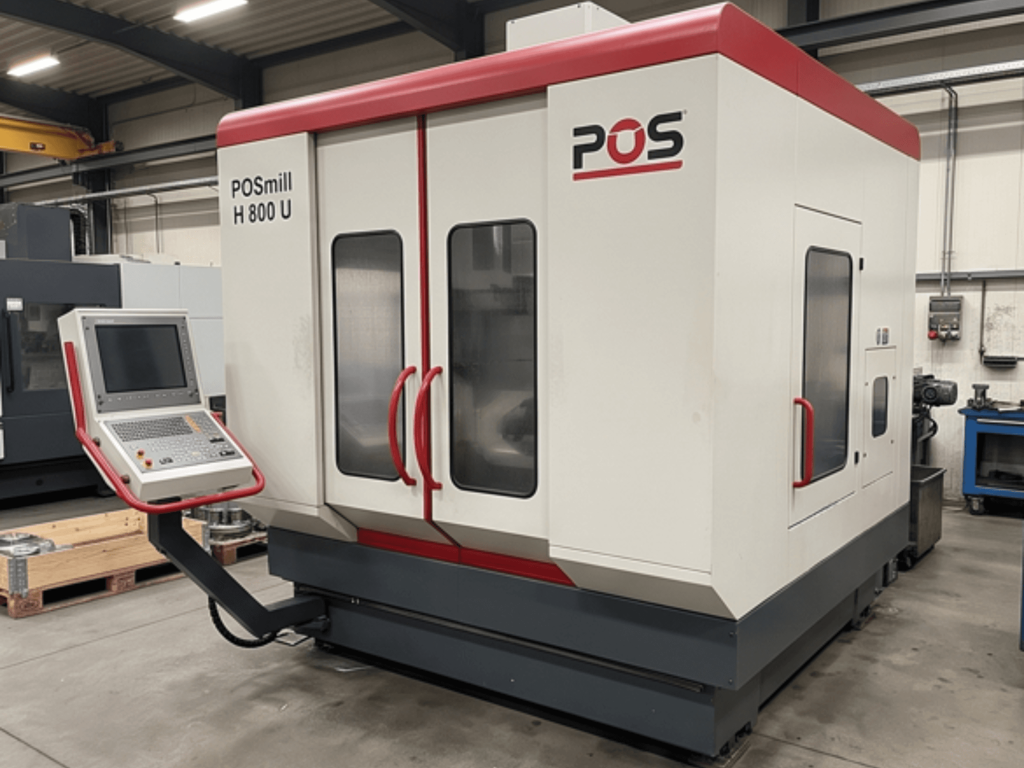 Centre d'usinage vertical POSmill H800U dans un atelier, équipé d'un panneau de commande et de deux portes vitrées. Vue de profil.