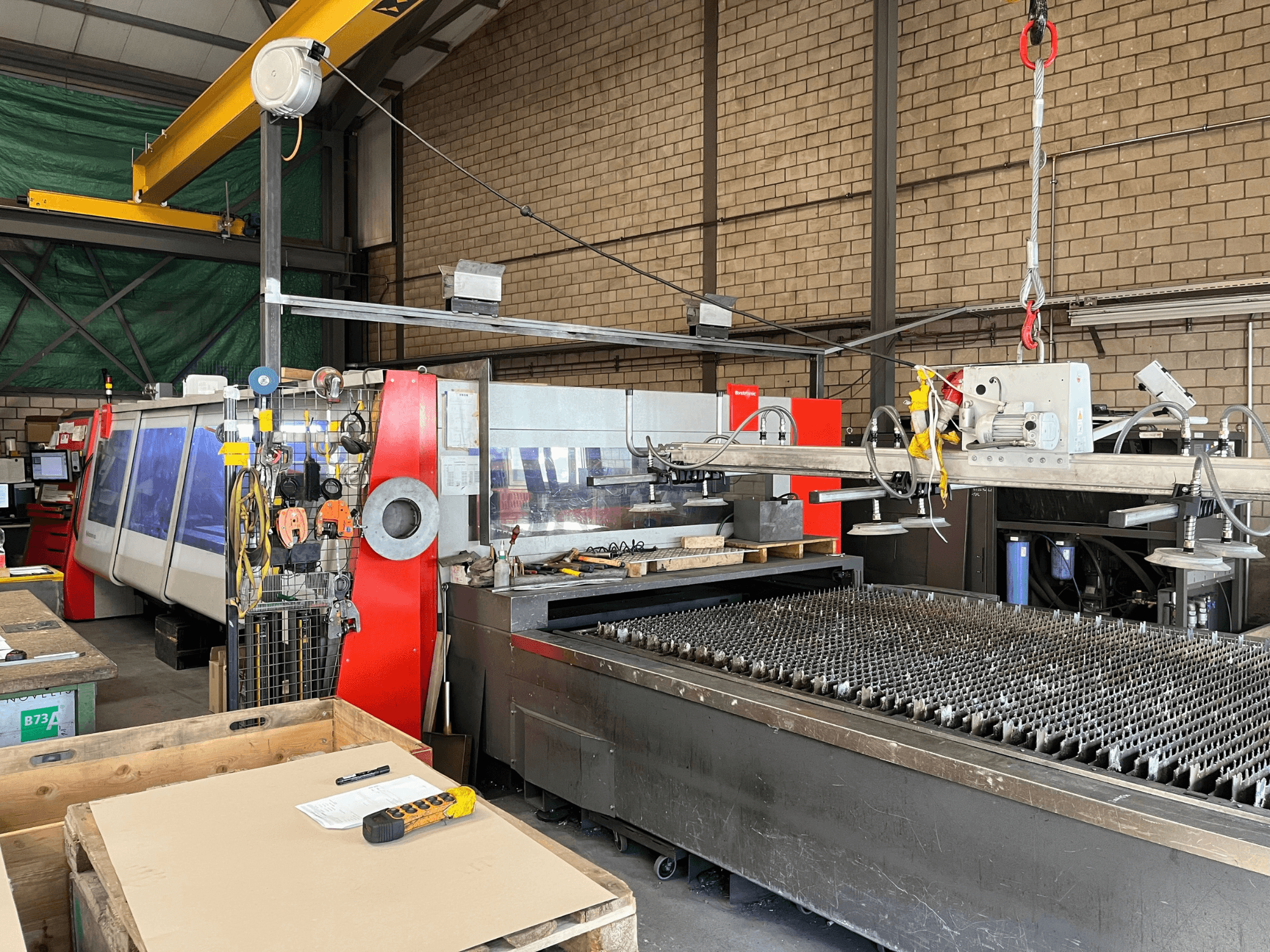 Machine de découpe au laser CO₂ Bystronic ByAutonom 4020, vue de profil avec table de travail, panneau de commande et pont roulant à l'arrière-plan.