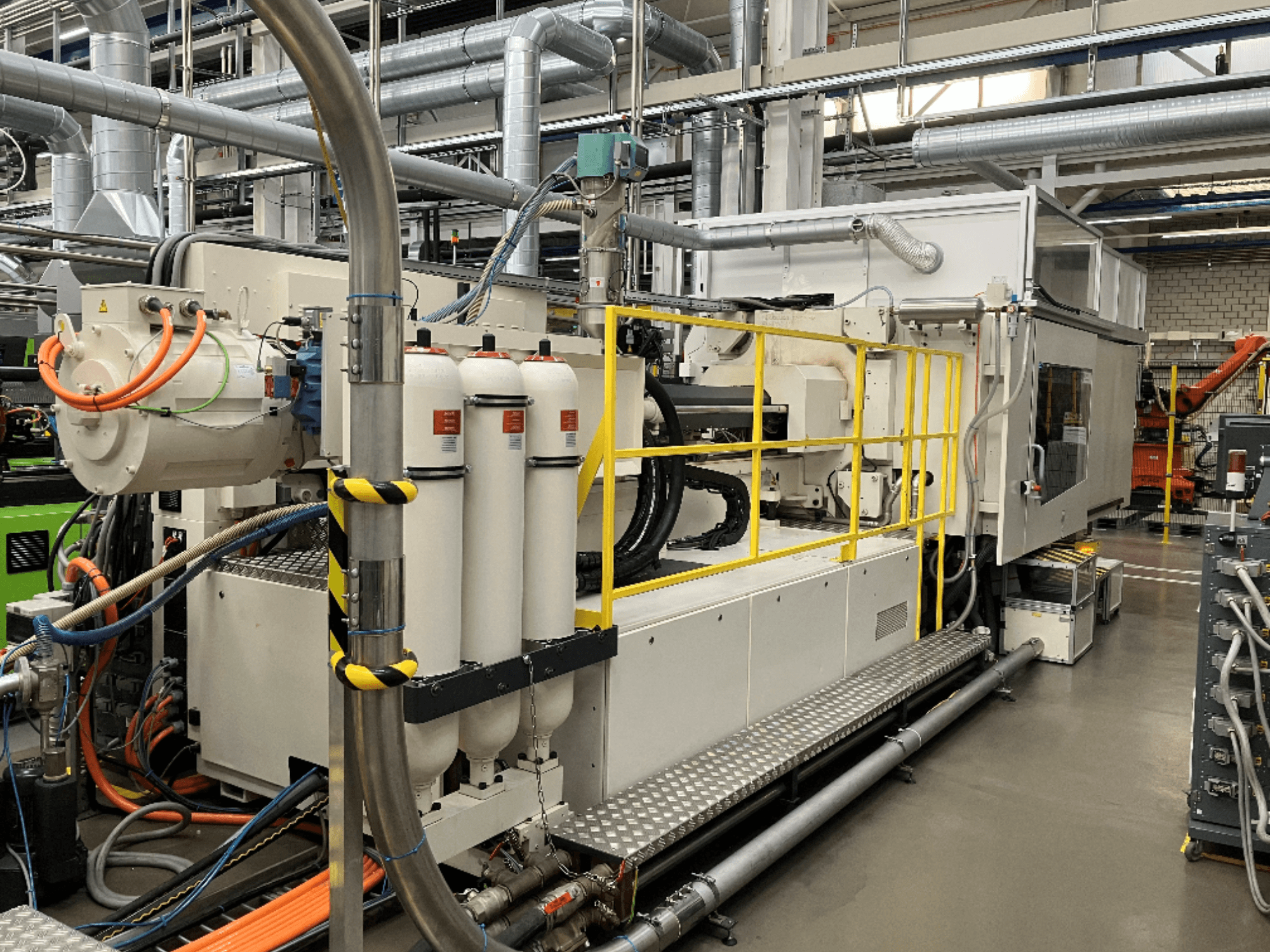 Machine industrielle avec carrosserie blanche et grise, plusieurs tuyaux et réservoirs de filtration ; vue latérale montrant la configuration opérationnelle.