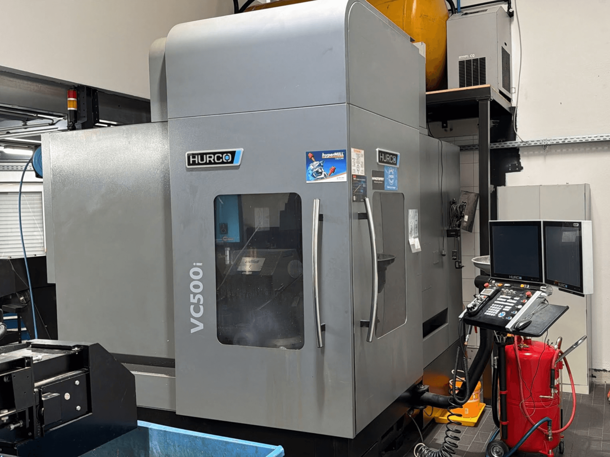 Centre d'usinage vertical Hurco VC500i, vue de face montrant le panneau de commande et les deux écrans, dans un atelier.