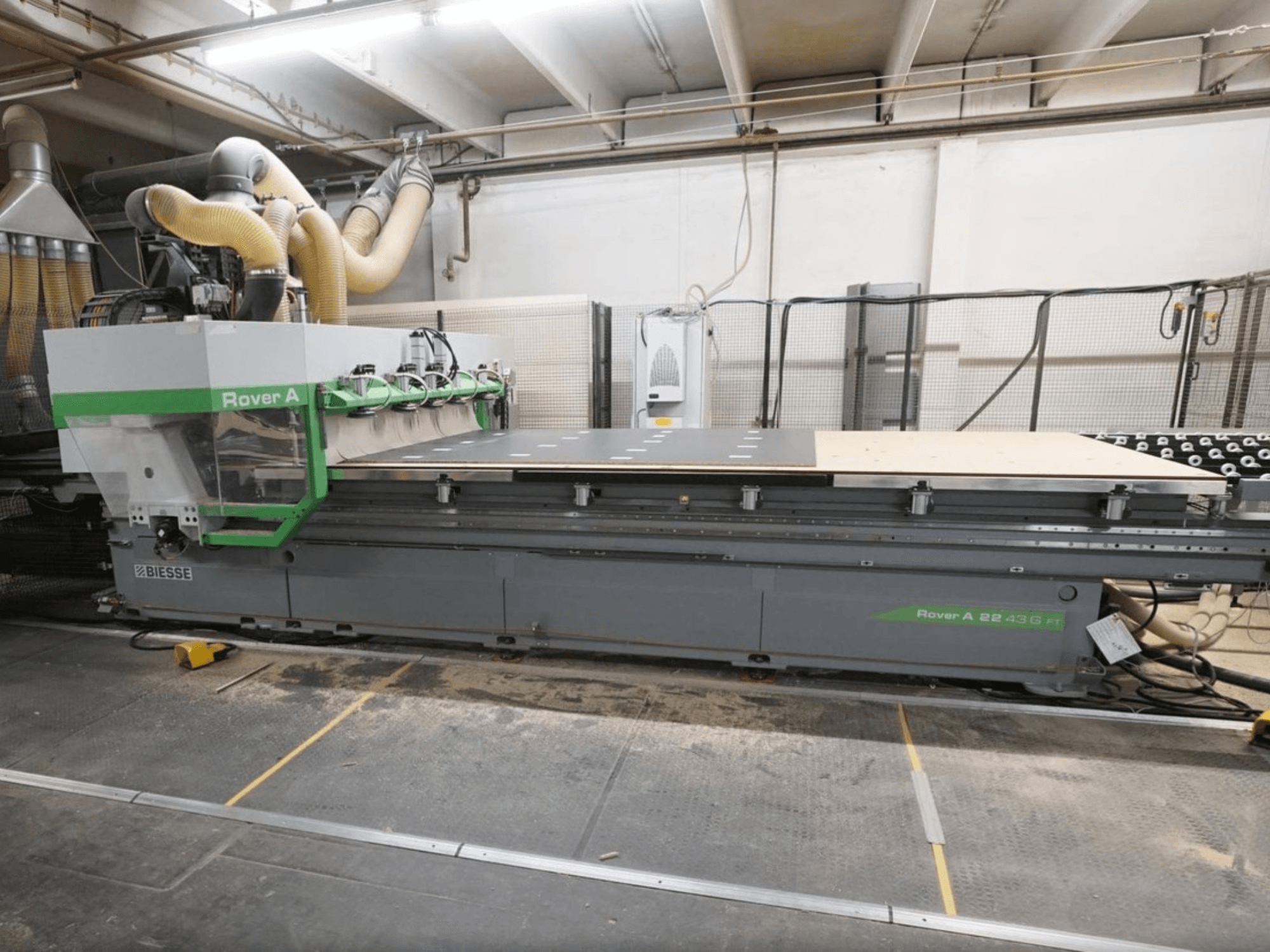Centre d'usinage CNC pour le bois BIESSE Rover A FT 2243, vue de face, doté d'une grande table de travail et d'un système de fixation des outils.
