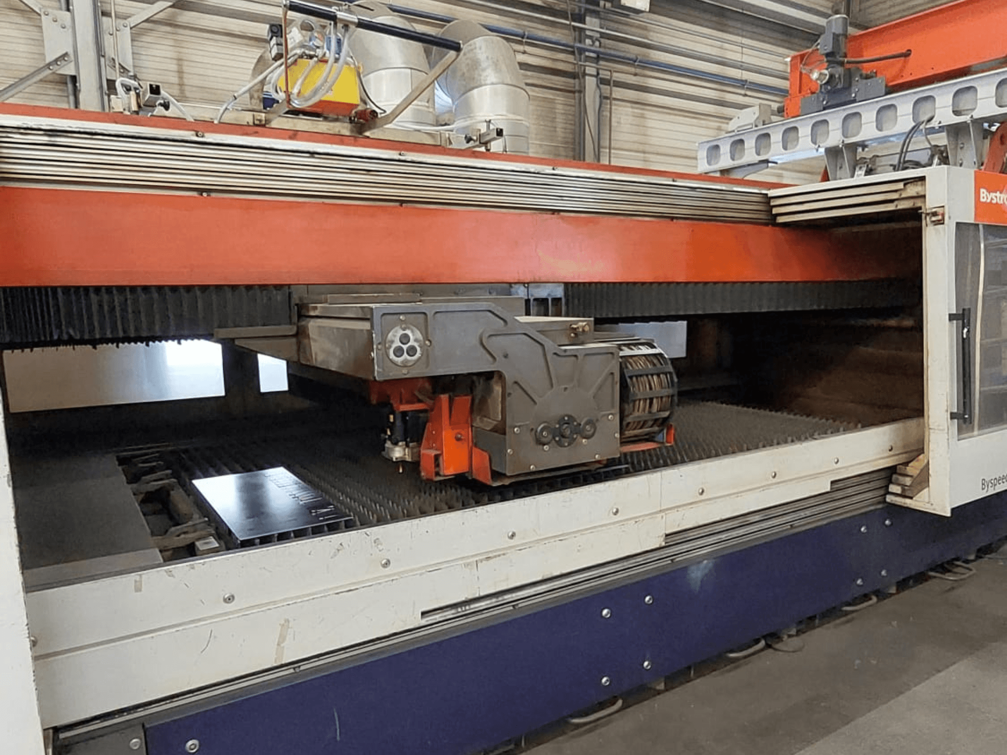 Machine de découpe laser CO₂ Bystronic BySpeed 3015, vue de face montrant la tête de découpe et la tôle posée sur le plateau de découpe.