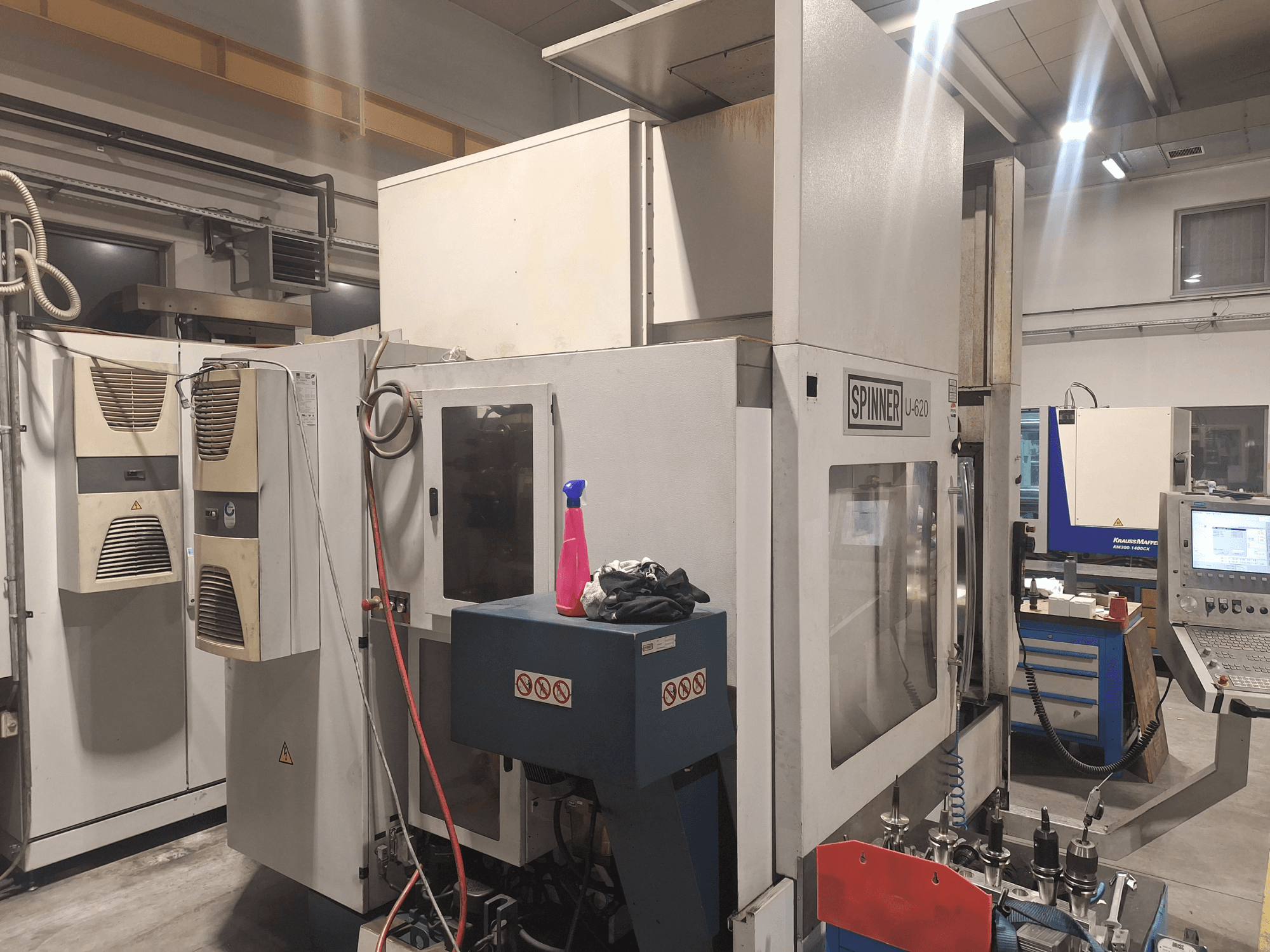 Machine CNC Spinner U-620 vue de face dans un atelier, avec panneau de commande et divers outils sur un établi à proximité.