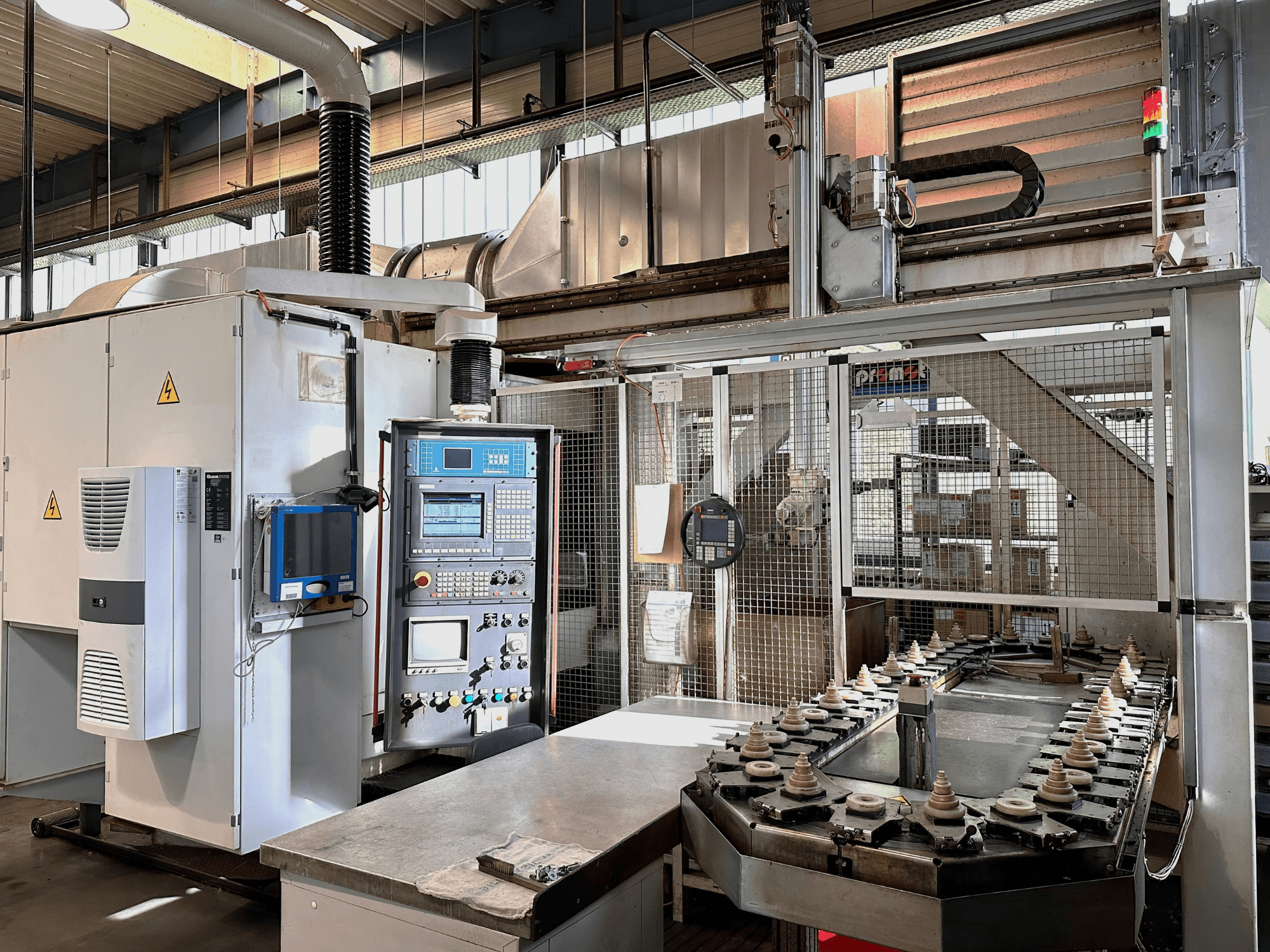 Machine industrielle avec panneau de commande, unité de refroidissement et convoyeur. Vue de face, avec des lumières vives et des panneaux de sécurité.