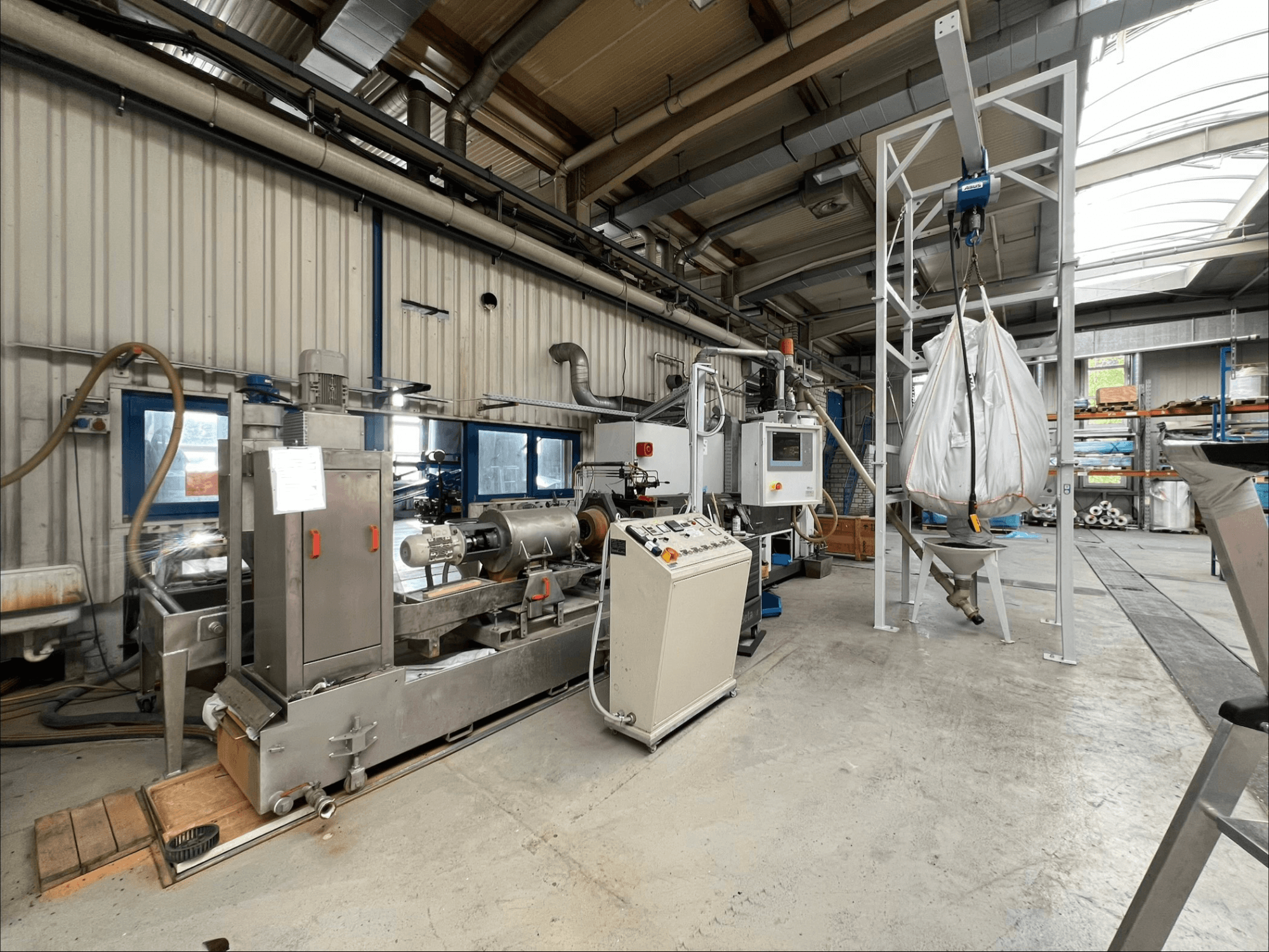 Vue de face de la machine de transformation des matières plastiques FILTEC GRP 350 dans un environnement industriel, avec ses commandes et son système d'alimentation.