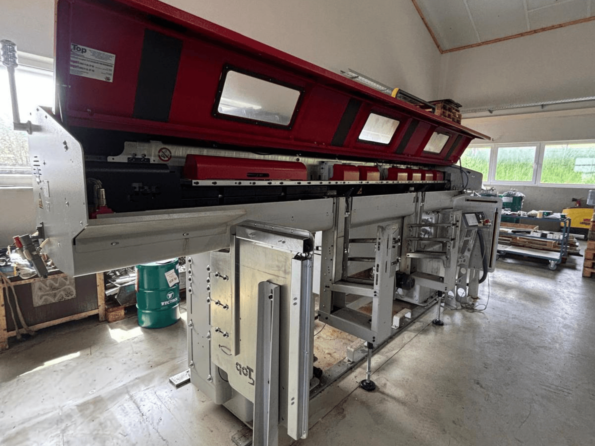 TOP Automazioni : vue de profil de la machine Top Loader ETL 10-75, avec sa partie supérieure rouge et ses composants mécaniques complexes.