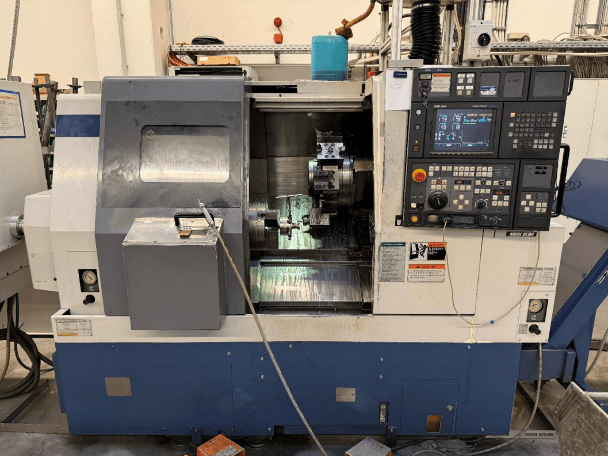 Centre de tournage-fraisage MORI SEIKI SL-250ASMC, vue de face montrant le panneau de commande et le mandrin porte-pièce en fonctionnement.