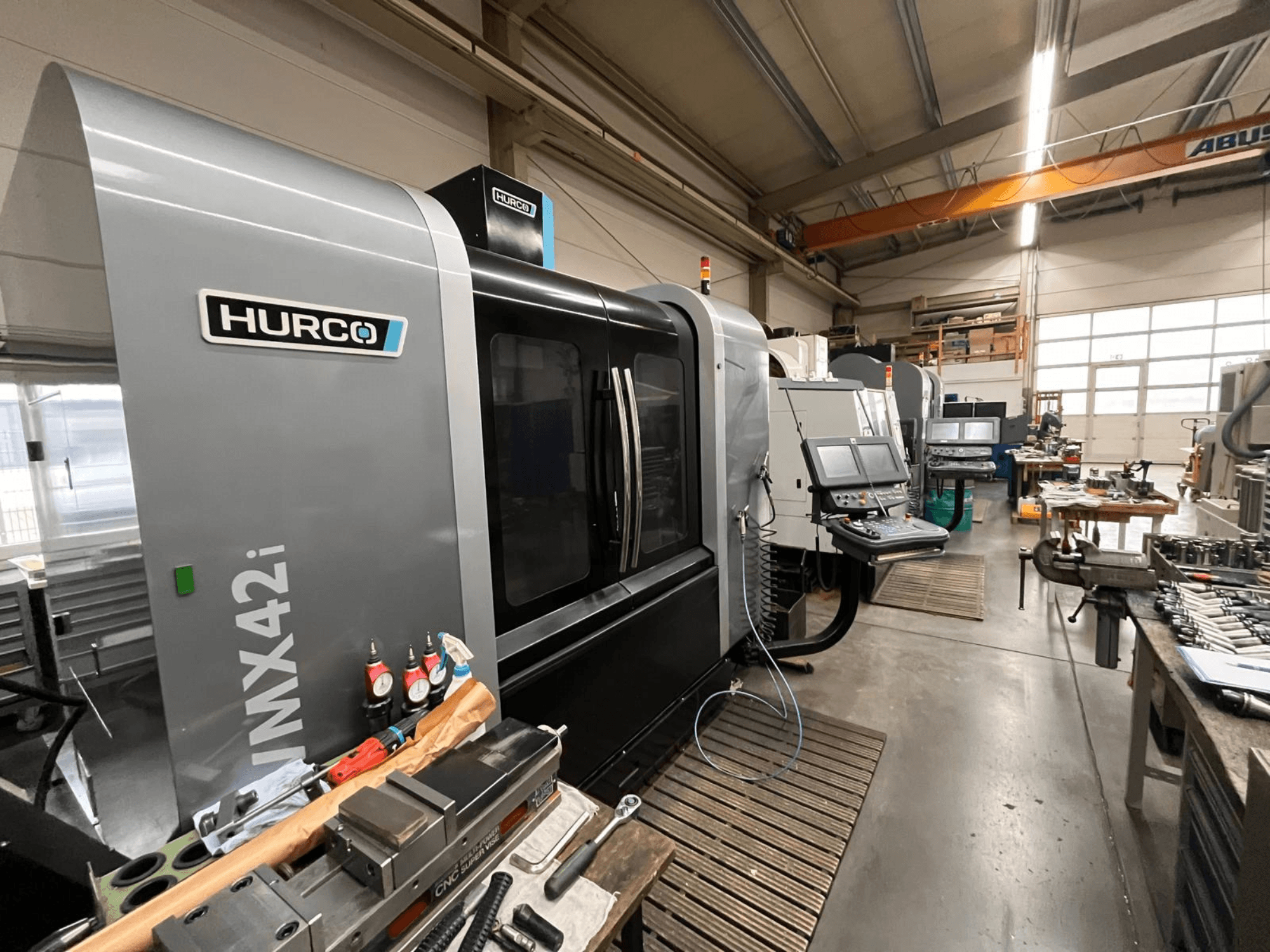 Machine CNC Hurco VMX42i dans un atelier, vue de face. Panneau de commande, carrosserie grise et environnement industriel.