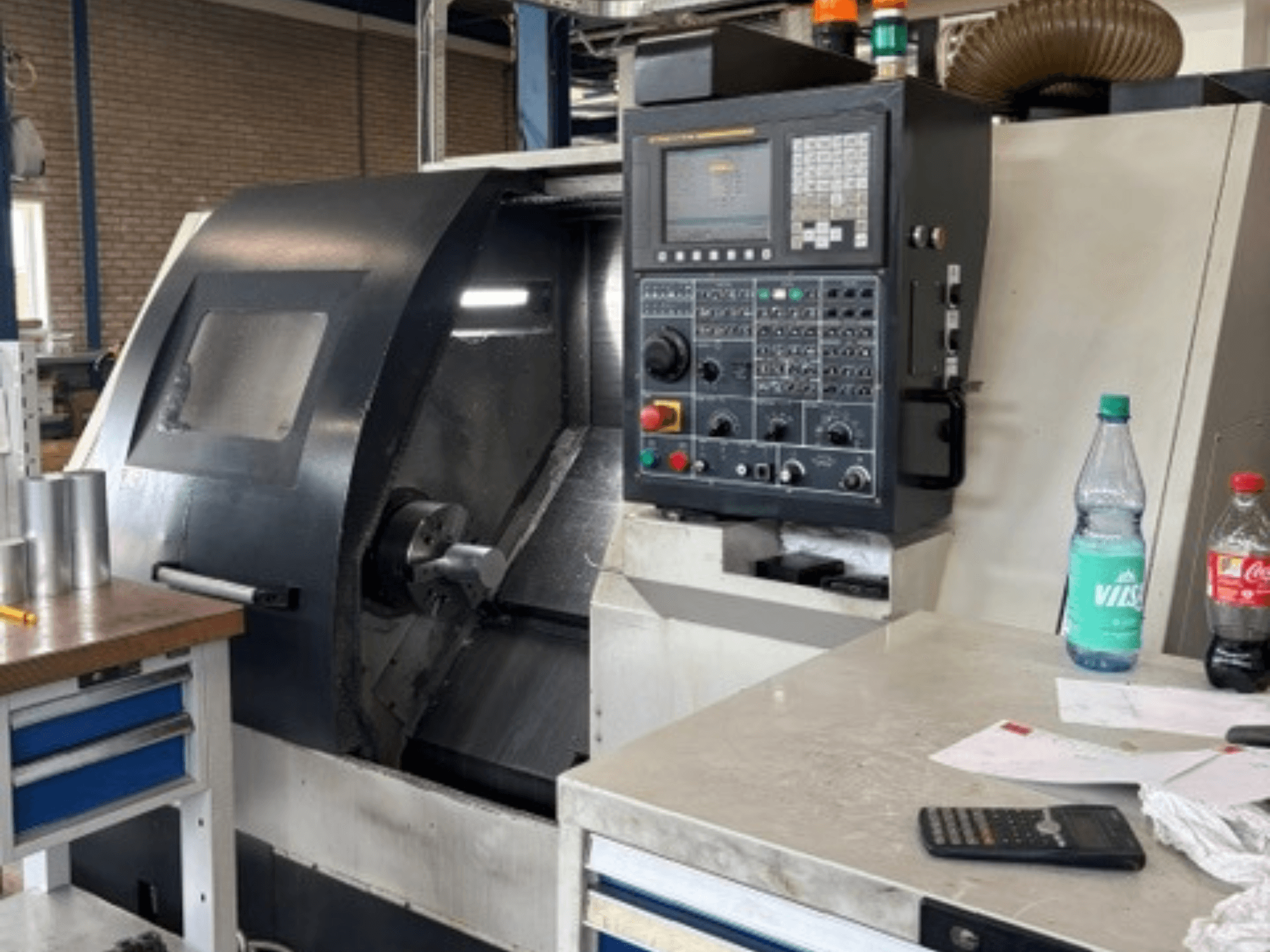 Tour horizontal Leadwell T-7, vue de face, avec le panneau de commande, la pièce à usiner posée sur le support d'outil et des détails de l'espace de travail visibles.