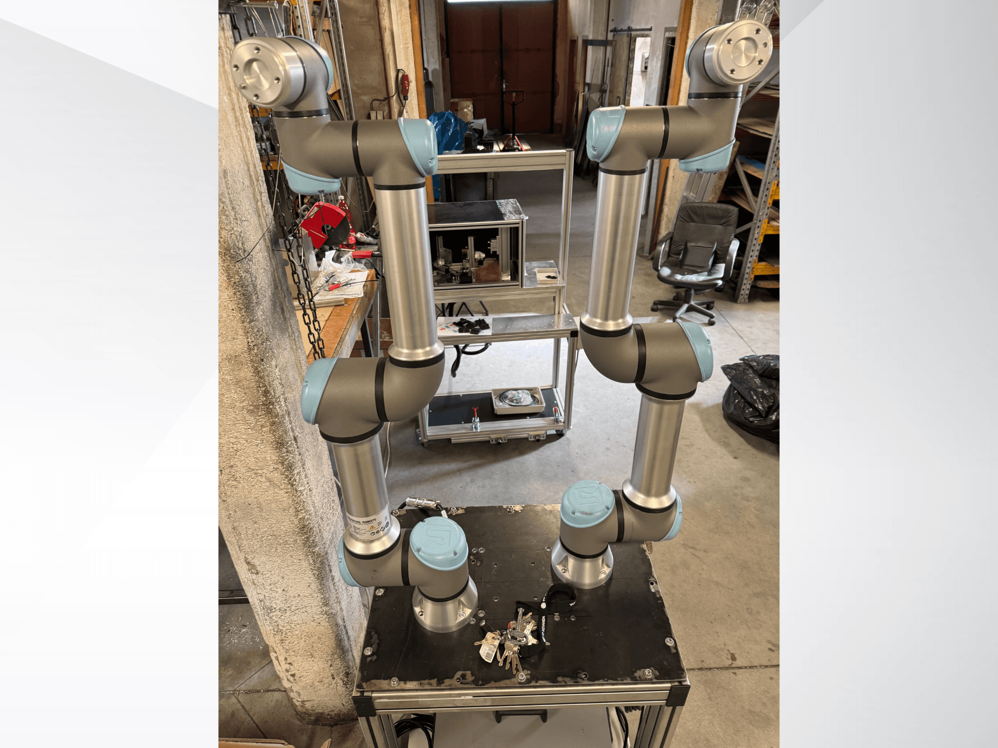 Bras robotique UR5e d'Universal Robots, vu de face, comportant six articulations avec des sections grises et bleues, montées sur une plate-forme noire.