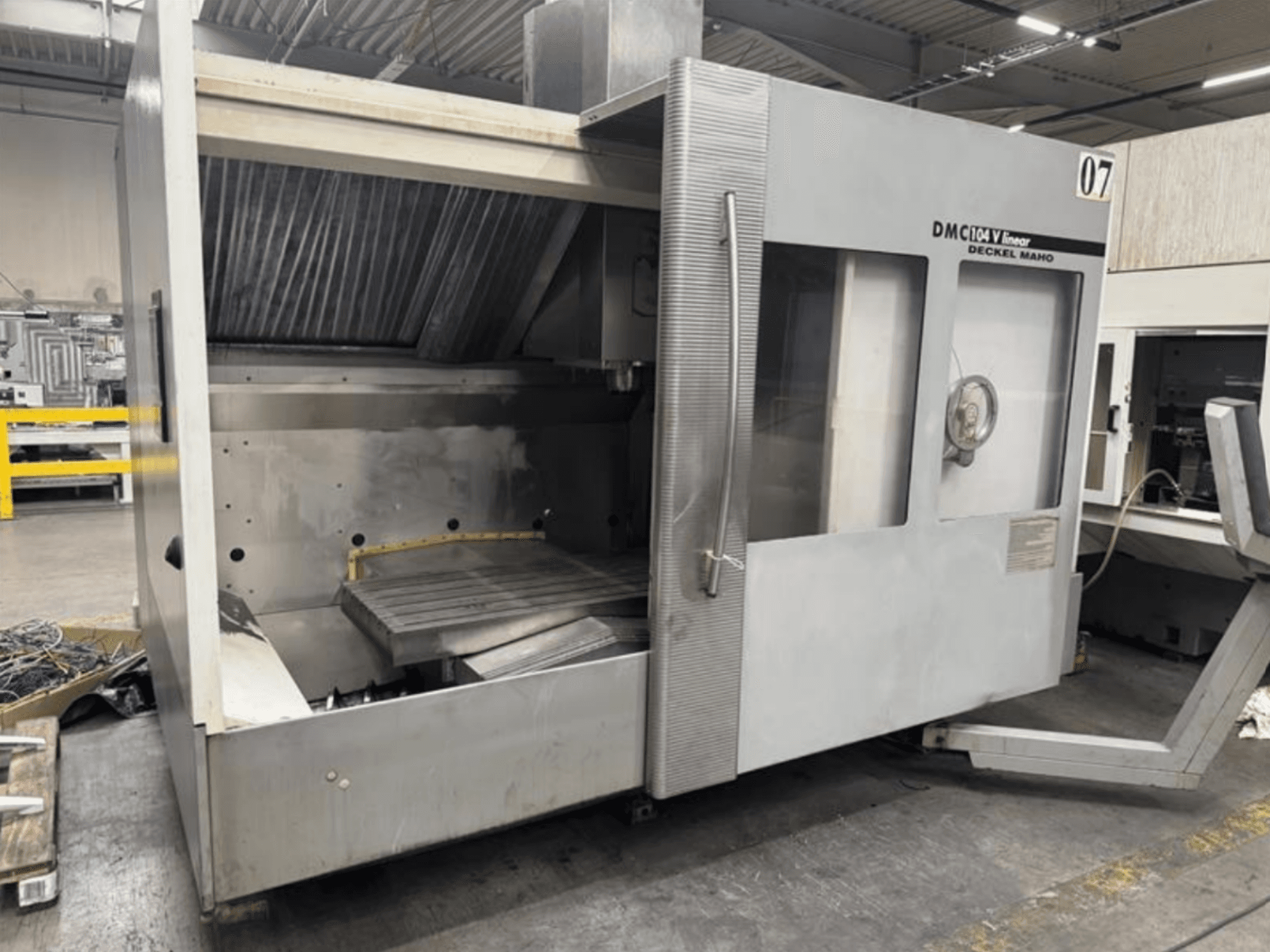 Machine linéaire DMC 104 V de Deckel Maho, vue de face, présentant une zone d'usinage vide avec une grande table de travail.