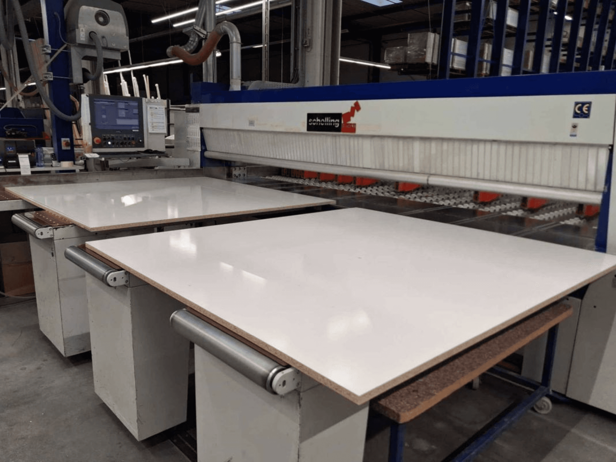 Vue avant de la scie à panneaux SCHELLING FM-H 430 avec la table de coupe blanche, le panneau de commande et la zone de la lame de scie visibles.