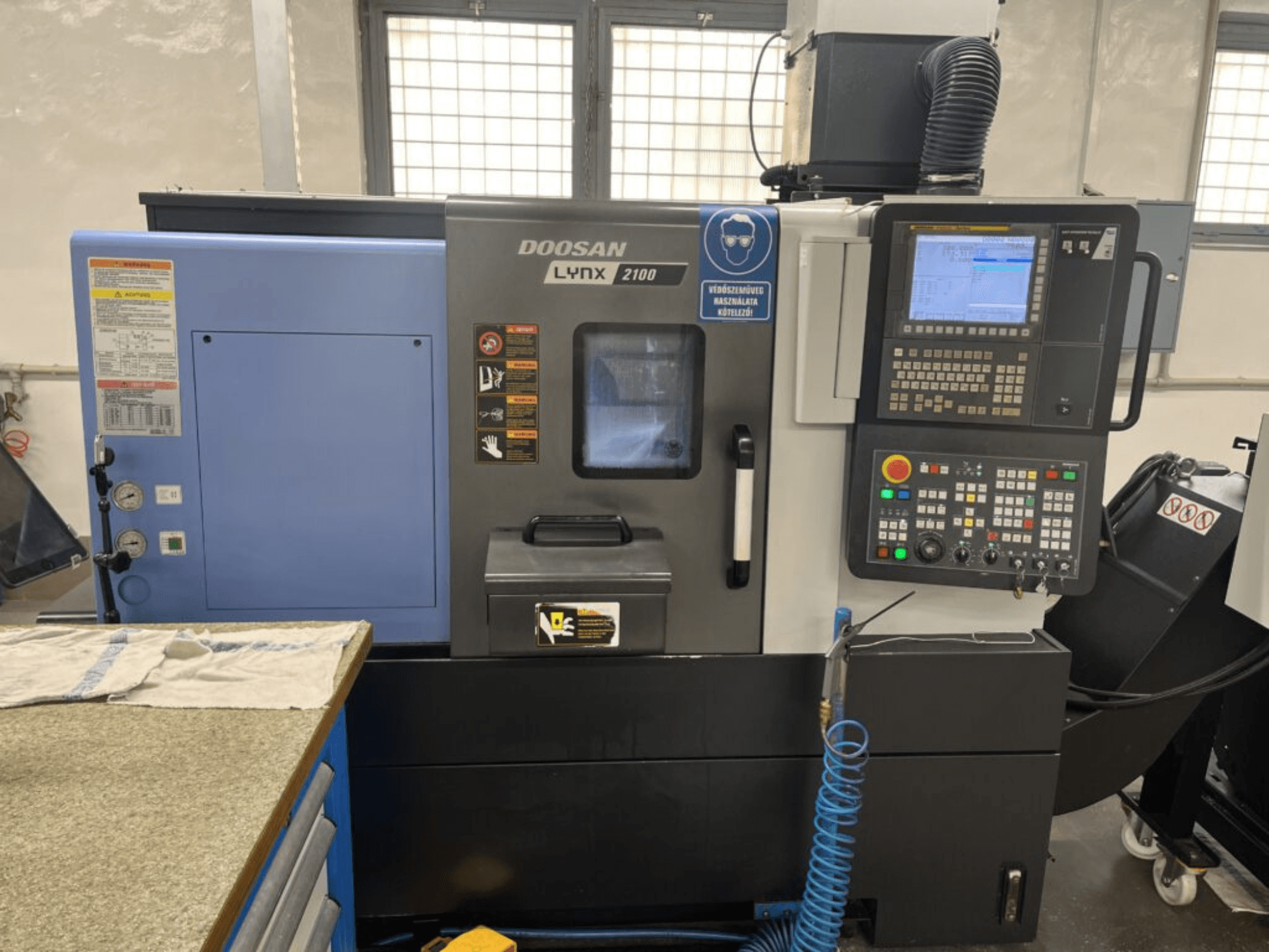Tour horizontal DOOSAN Lynx 2100A, vue de face présentant le panneau de commande, l'interface opérateur et les caractéristiques de la machine.