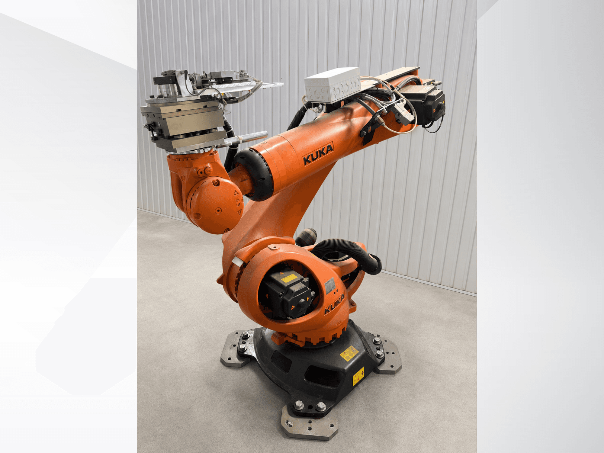 Bras de robot KUKA KR 90 R3100 supplémentaire, de couleur orange, vue de profil, mettant en évidence les articulations, le contrôleur et l'outil fixé à l'effecteur terminal.