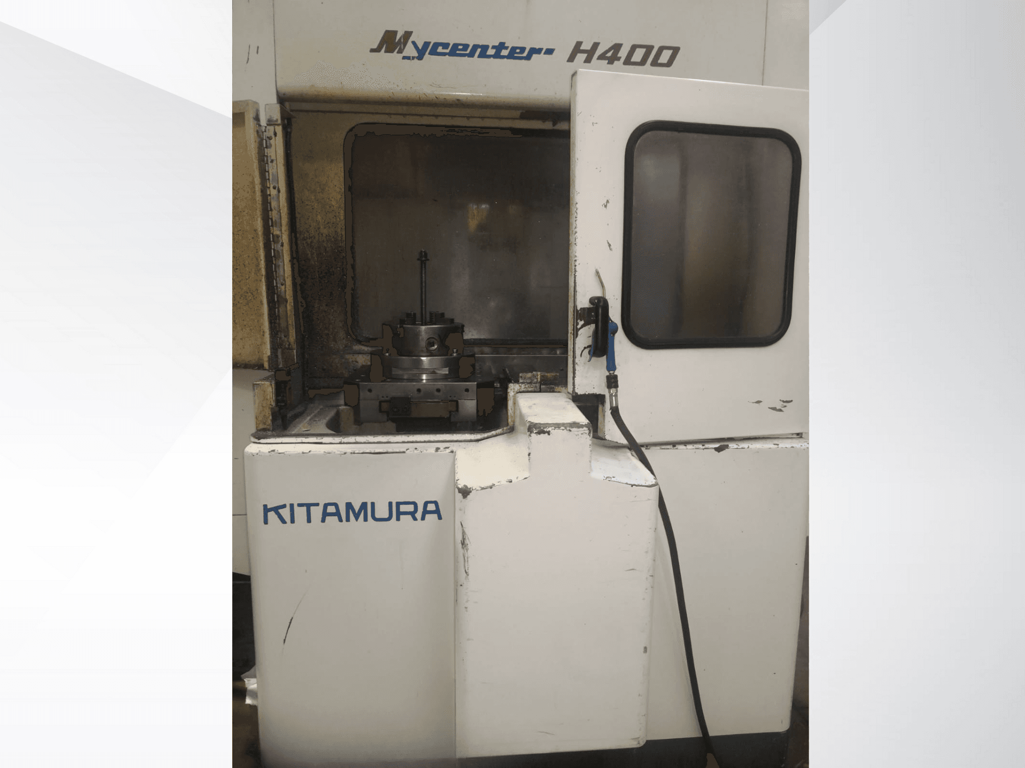 Machine CNC Kitamura Mycenter H400, vue de face, avec zone de travail et panneau de commande visibles, présentant des signes d'utilisation.